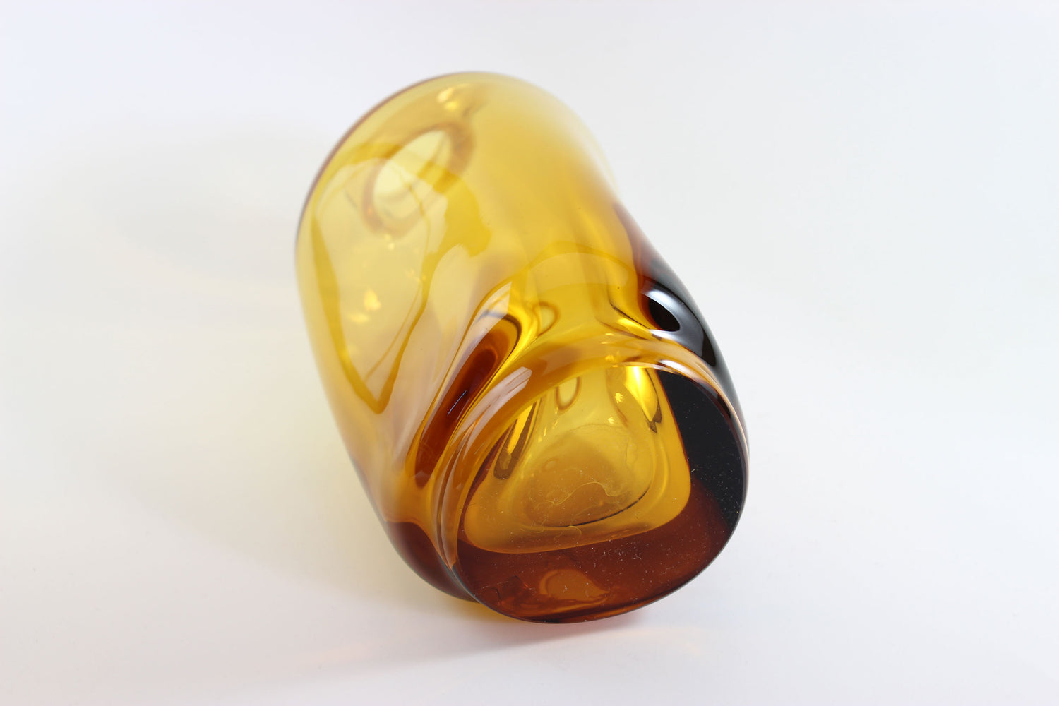 Set of amber pinched glass decanter and six glasses on a white background