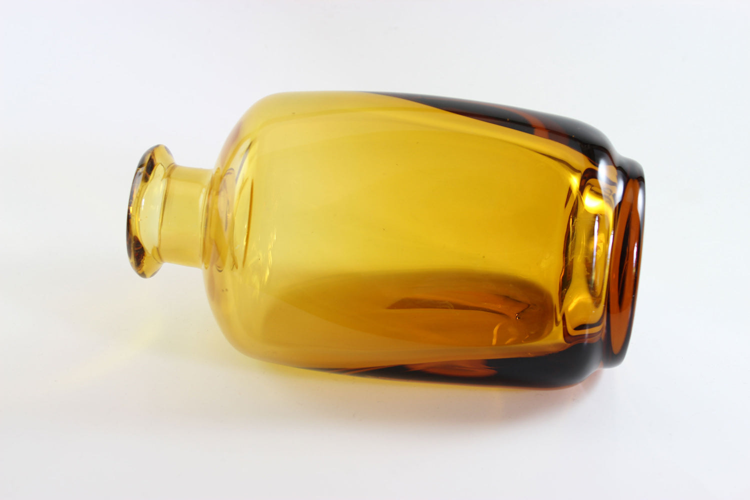 Set of amber pinched glass decanter and six glasses on a white background