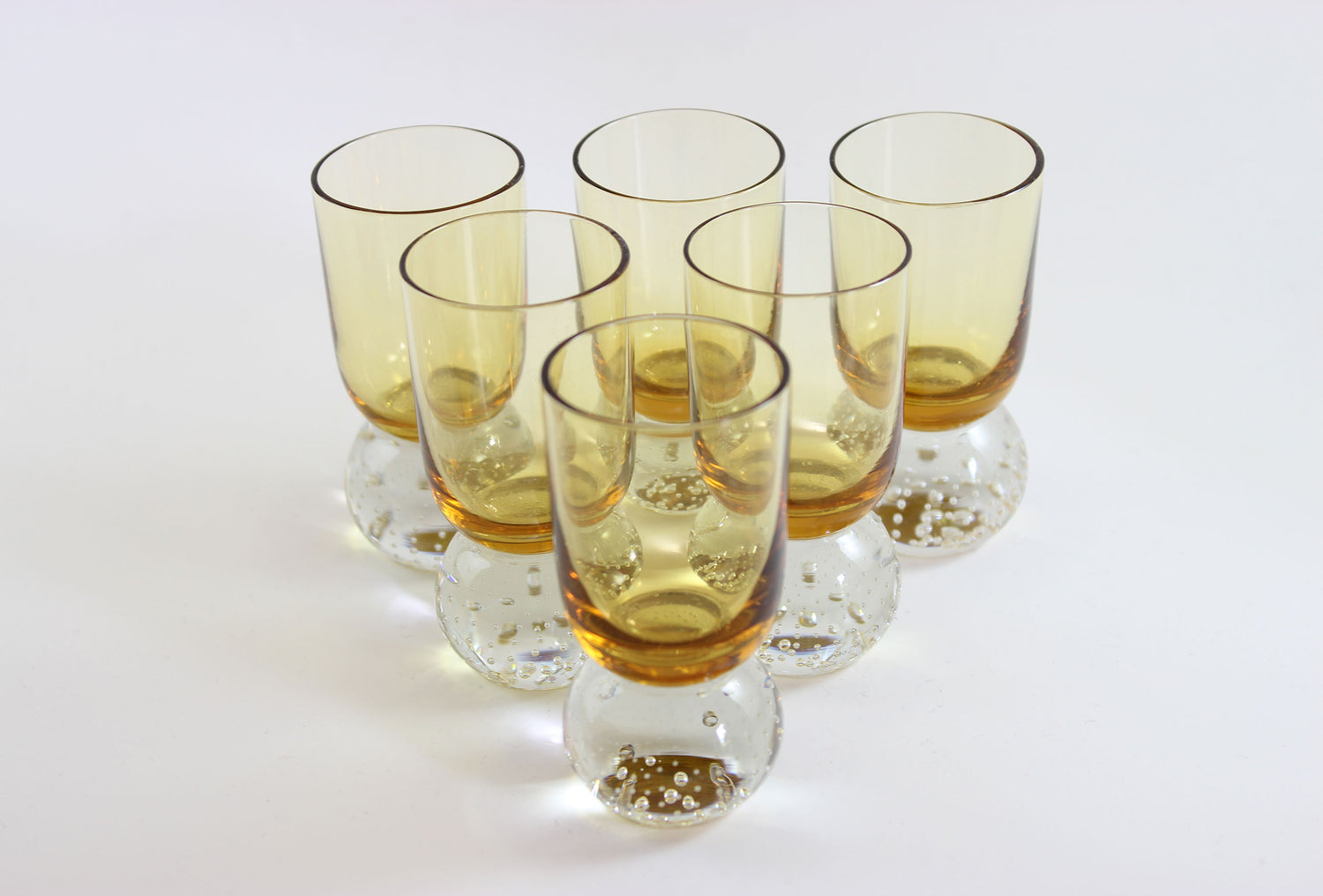 Set of amber pinched glass decanter and six glasses on a white background