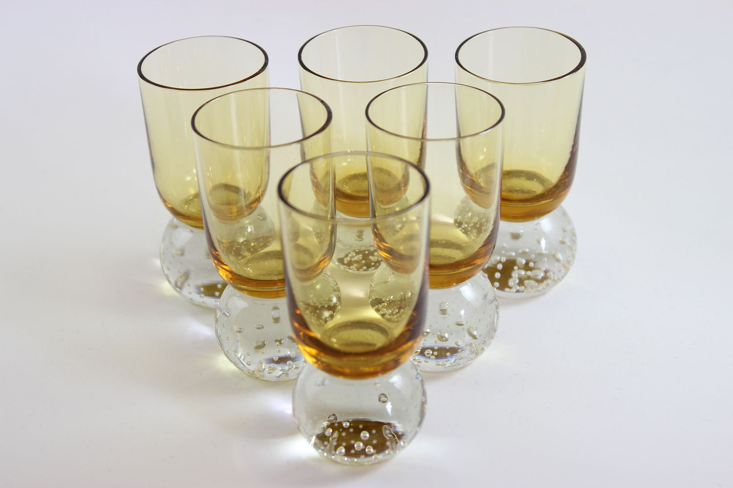 Set of amber pinched glass decanter and six glasses on a white background