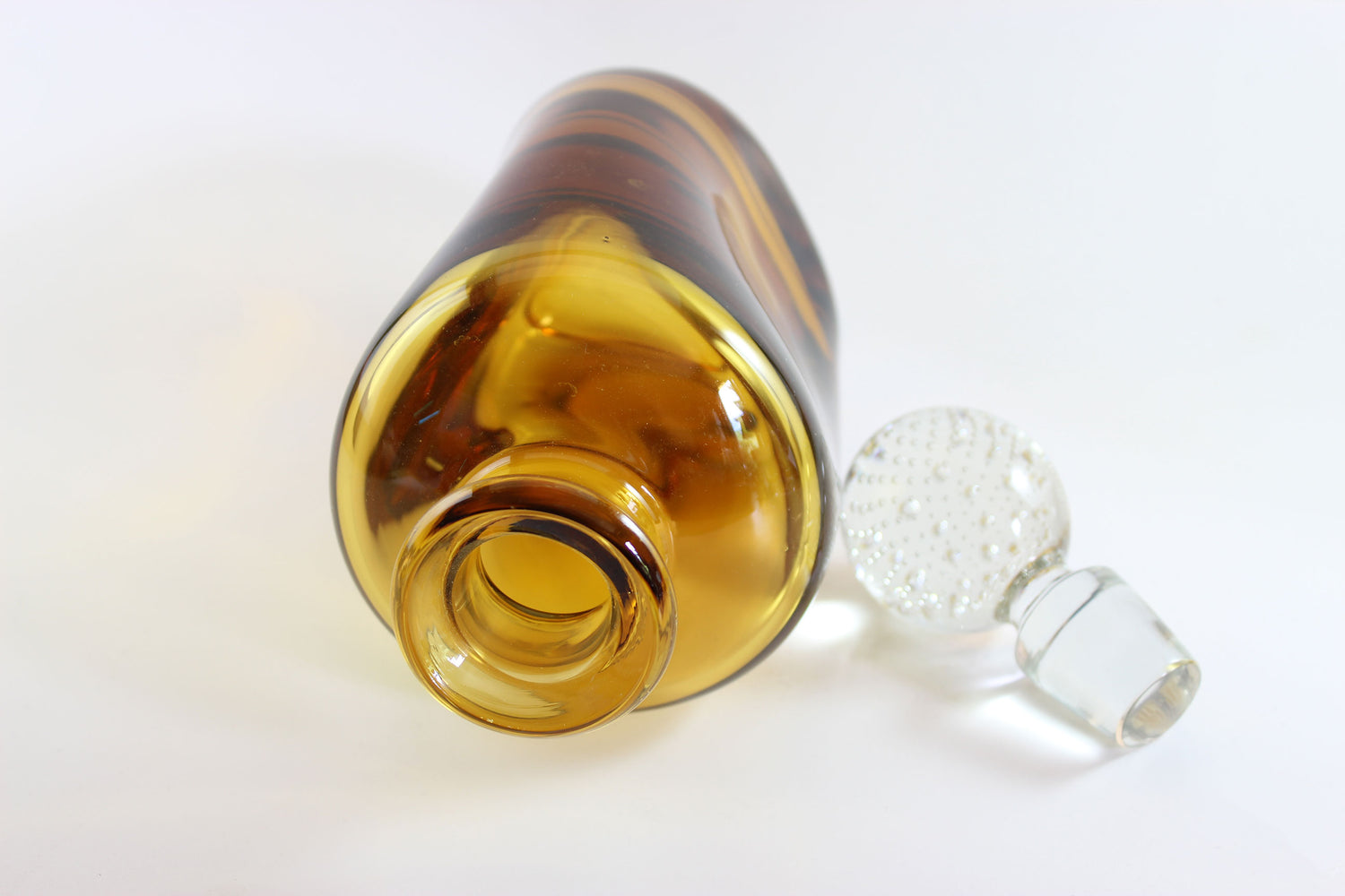 Set of amber pinched glass decanter and six glasses on a white background