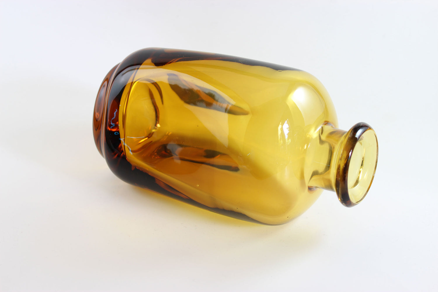 Set of amber pinched glass decanter and six glasses on a white background