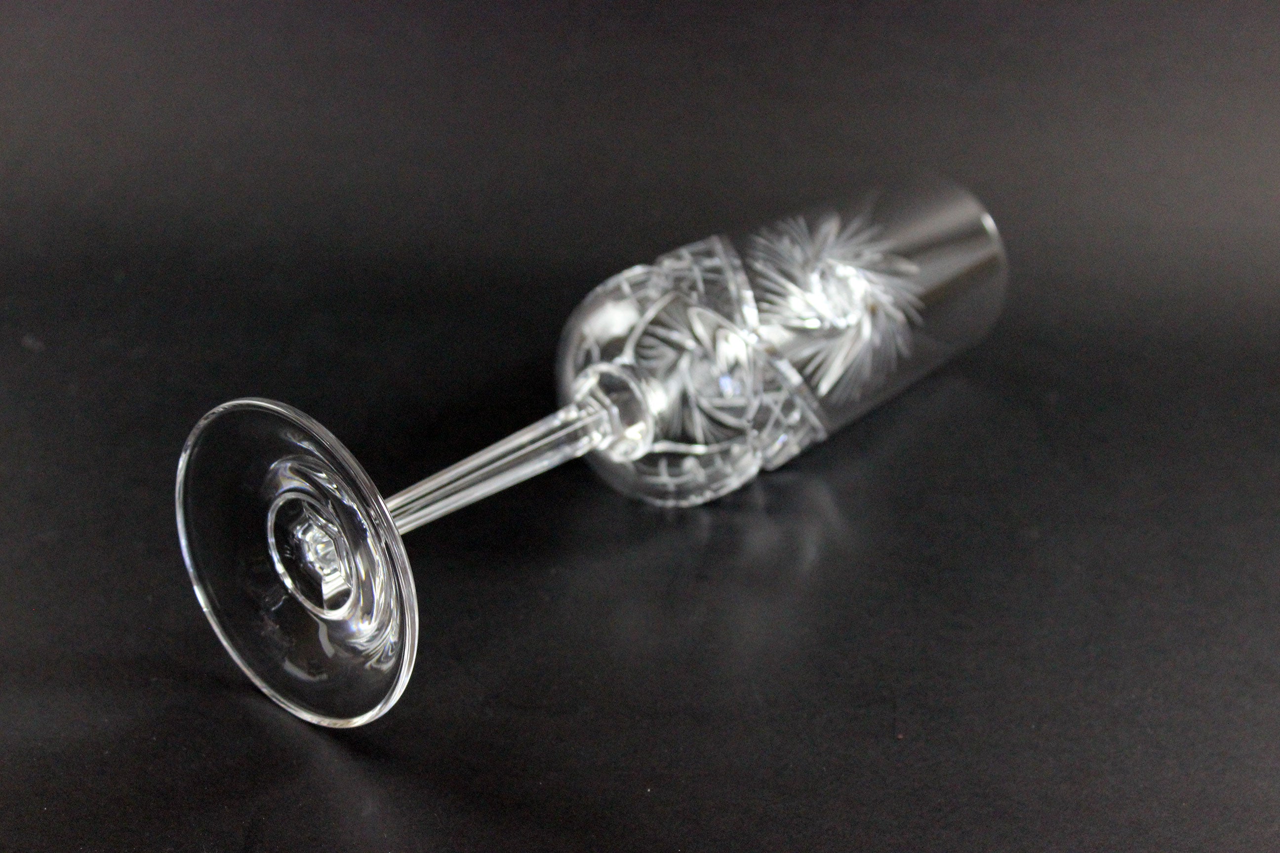 Crystal champagne flute with cut pinwheel design on a black background