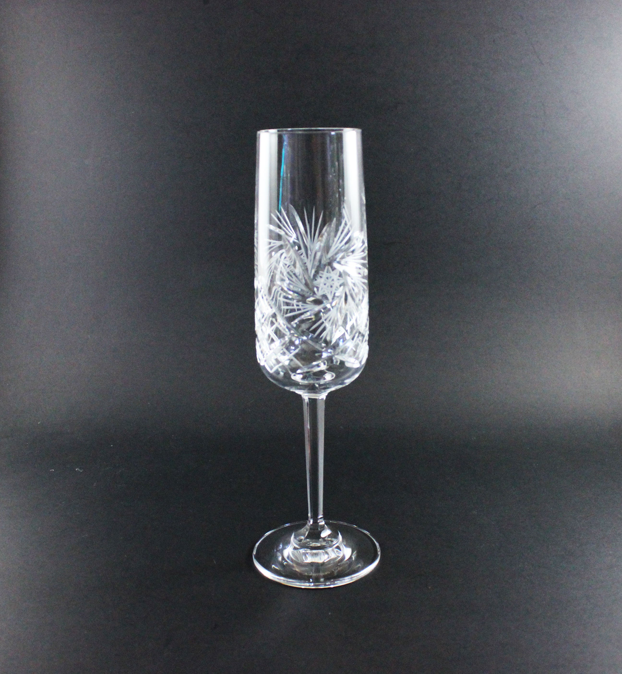 Crystal champagne flute with intricate design on a black background