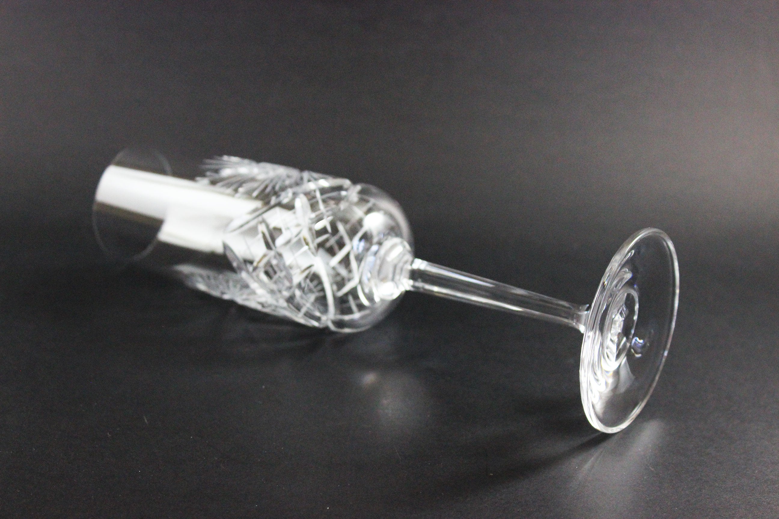 Crystal champagne flutes with cut design on a black background