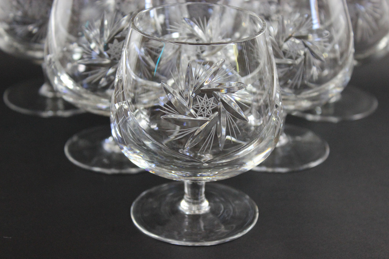 Set of crystal glasses with intricate designs on a black background