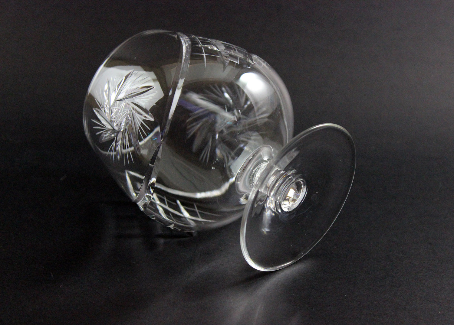 Crystal glass with intricate cut design on a black background