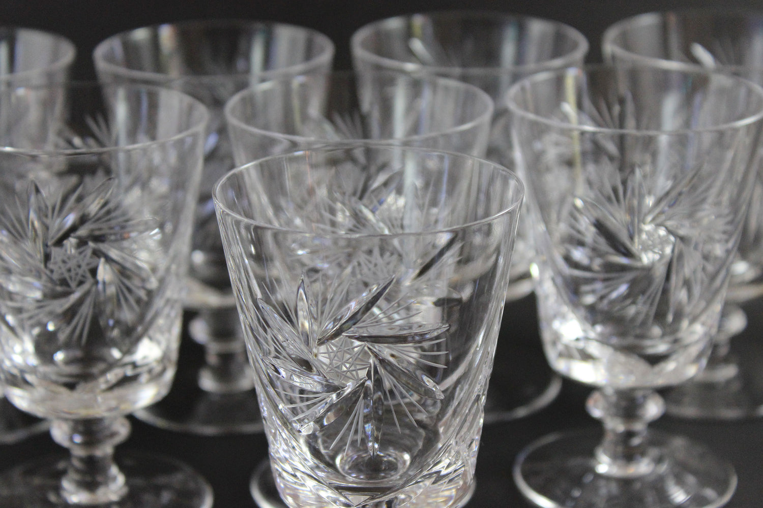 Set of crystal glasses with intricate designs on a dark background