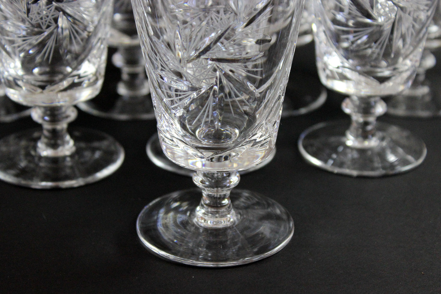 Set of crystal glasses with intricate designs on a black background