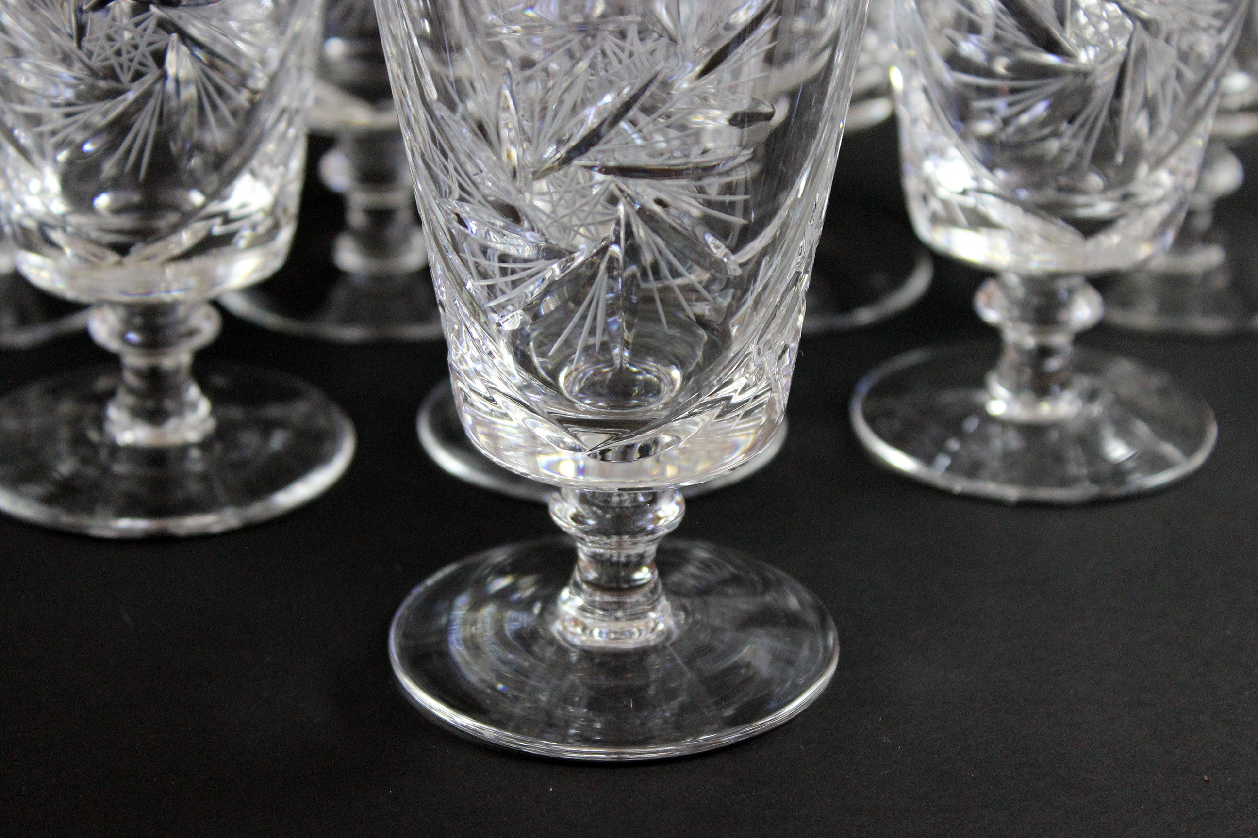 Set of crystal glasses with intricate designs on a black background