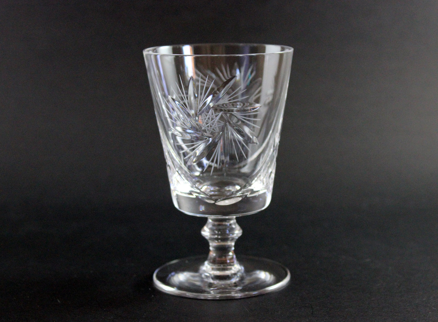 Clear crystal glass with intricate etching on a black background