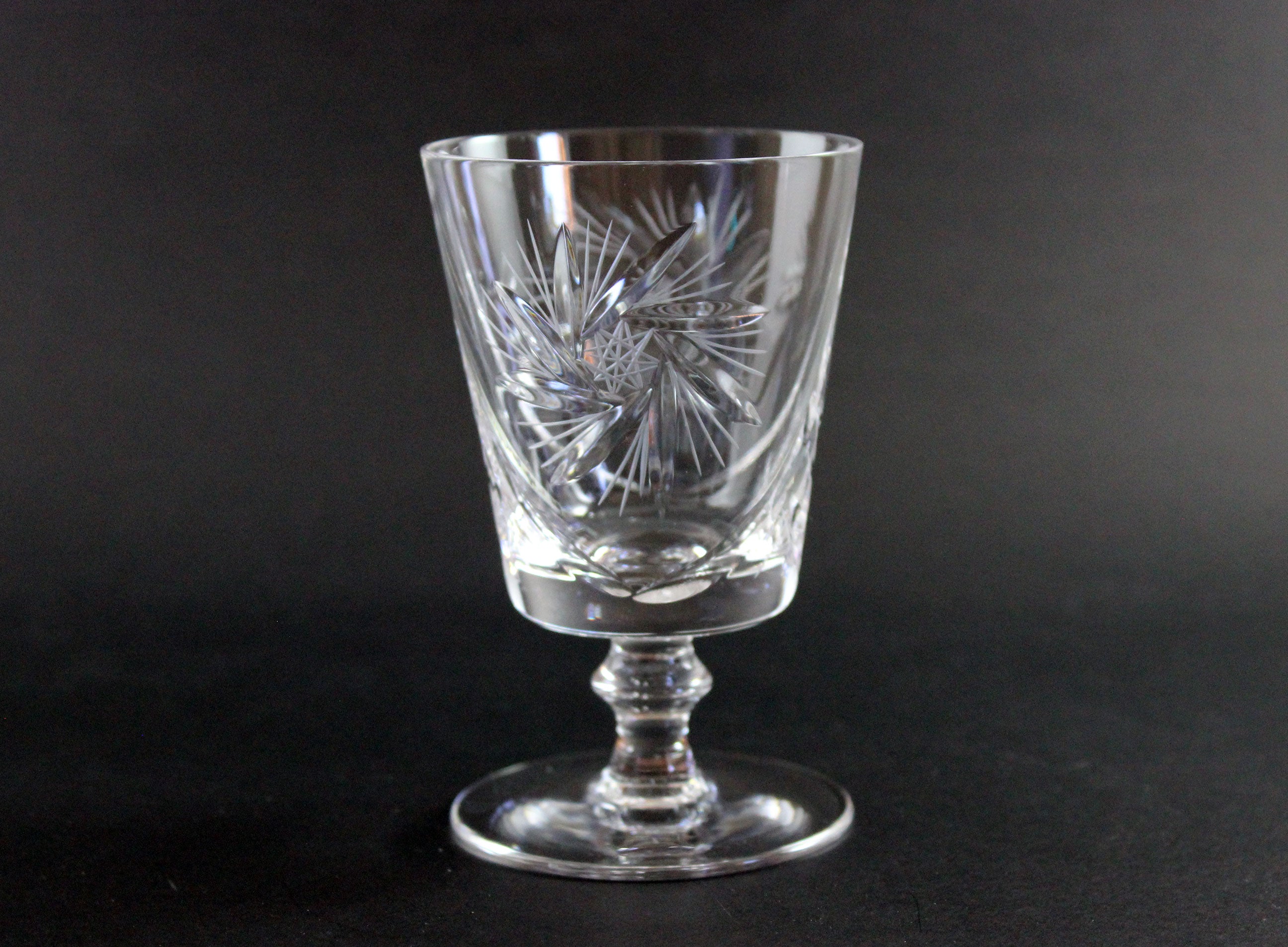Clear crystal glass with intricate etching on a black background