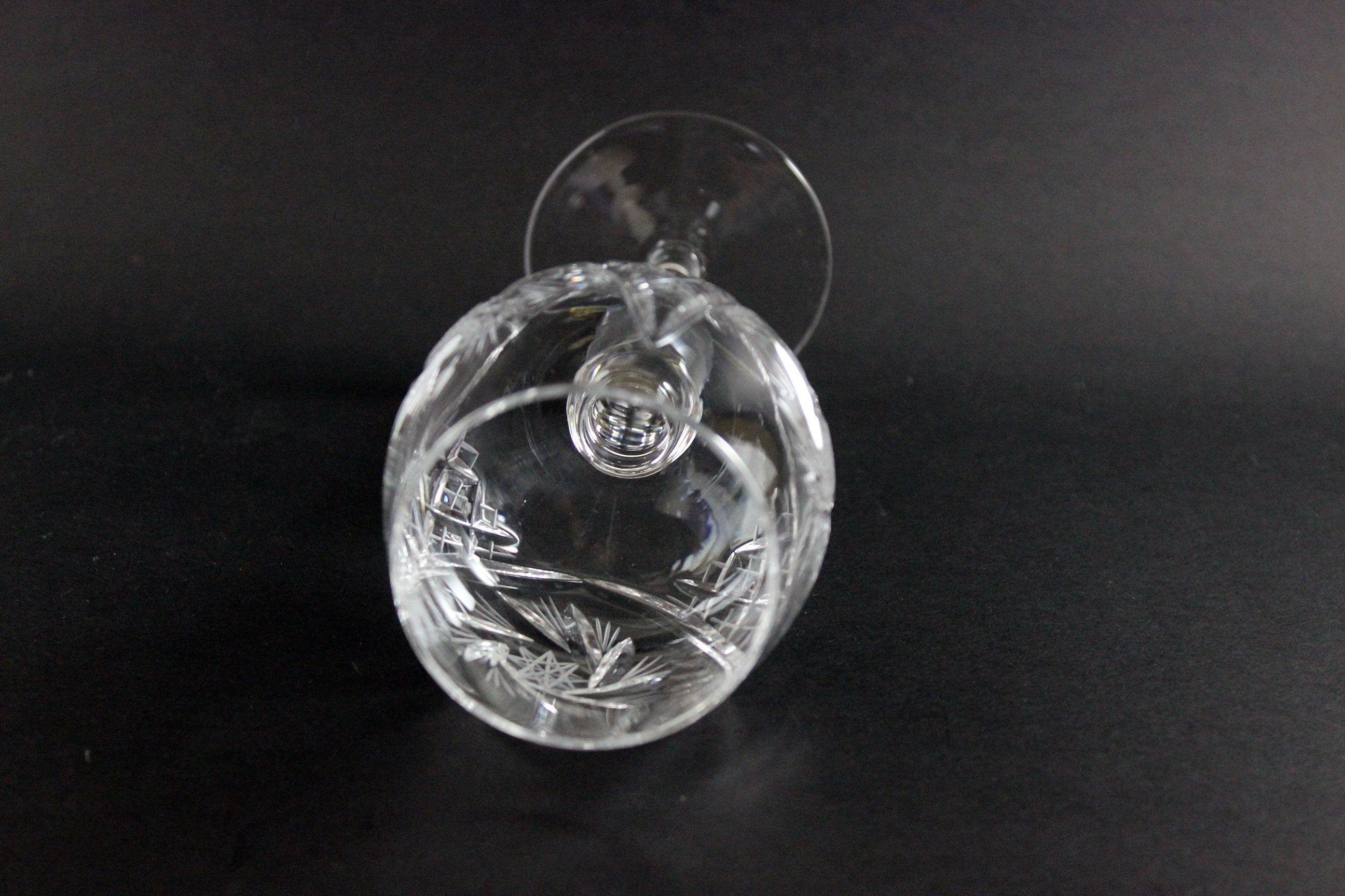 Clear crystal wine goblet with cut design on a black background