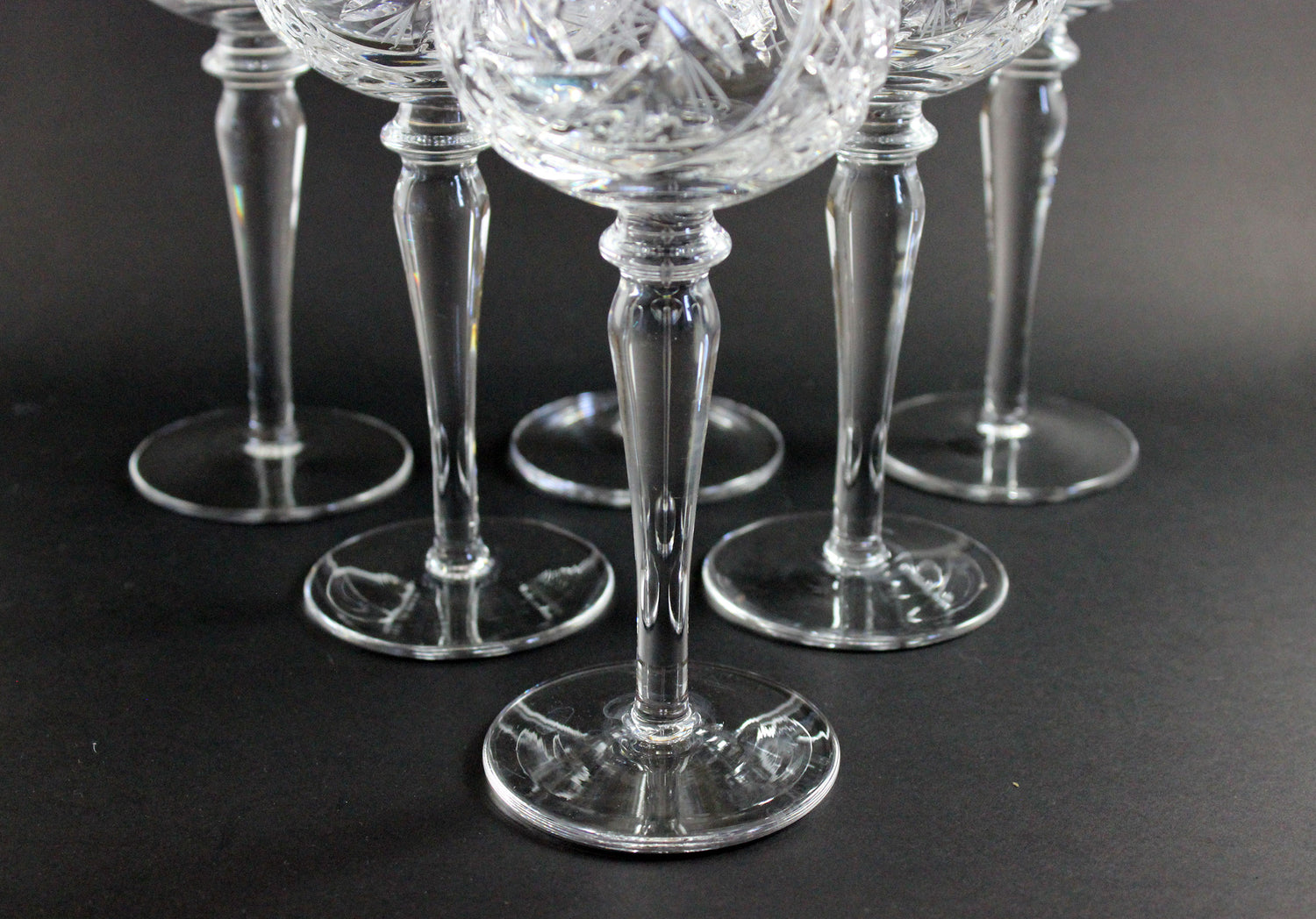 Set of clear crystal wine glasses on a black background