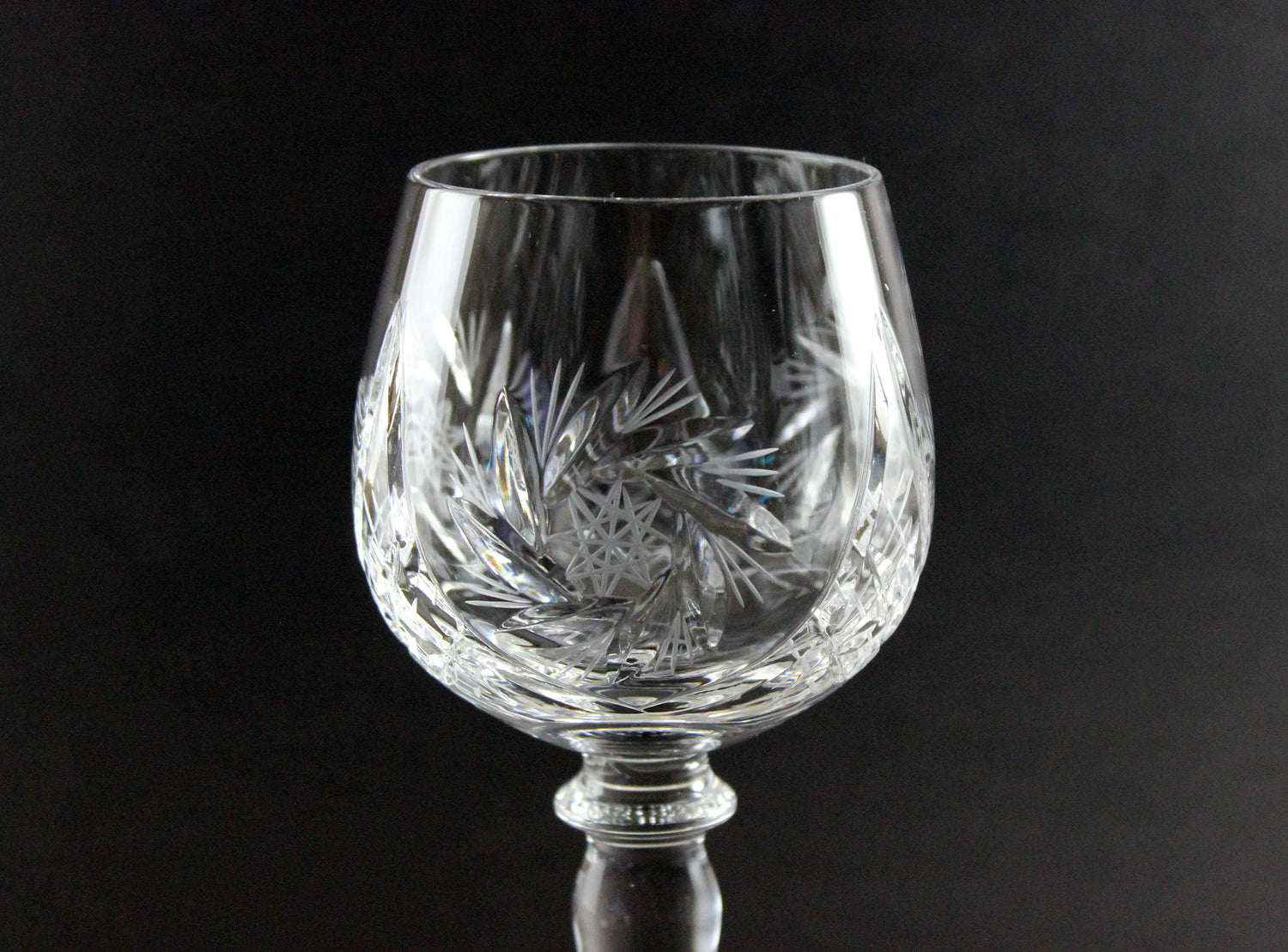 Crystal glass with intricate cut patterns on a black background
