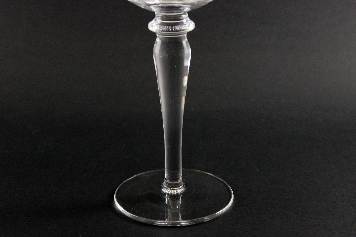 Clear crystal goblet stem on a black background