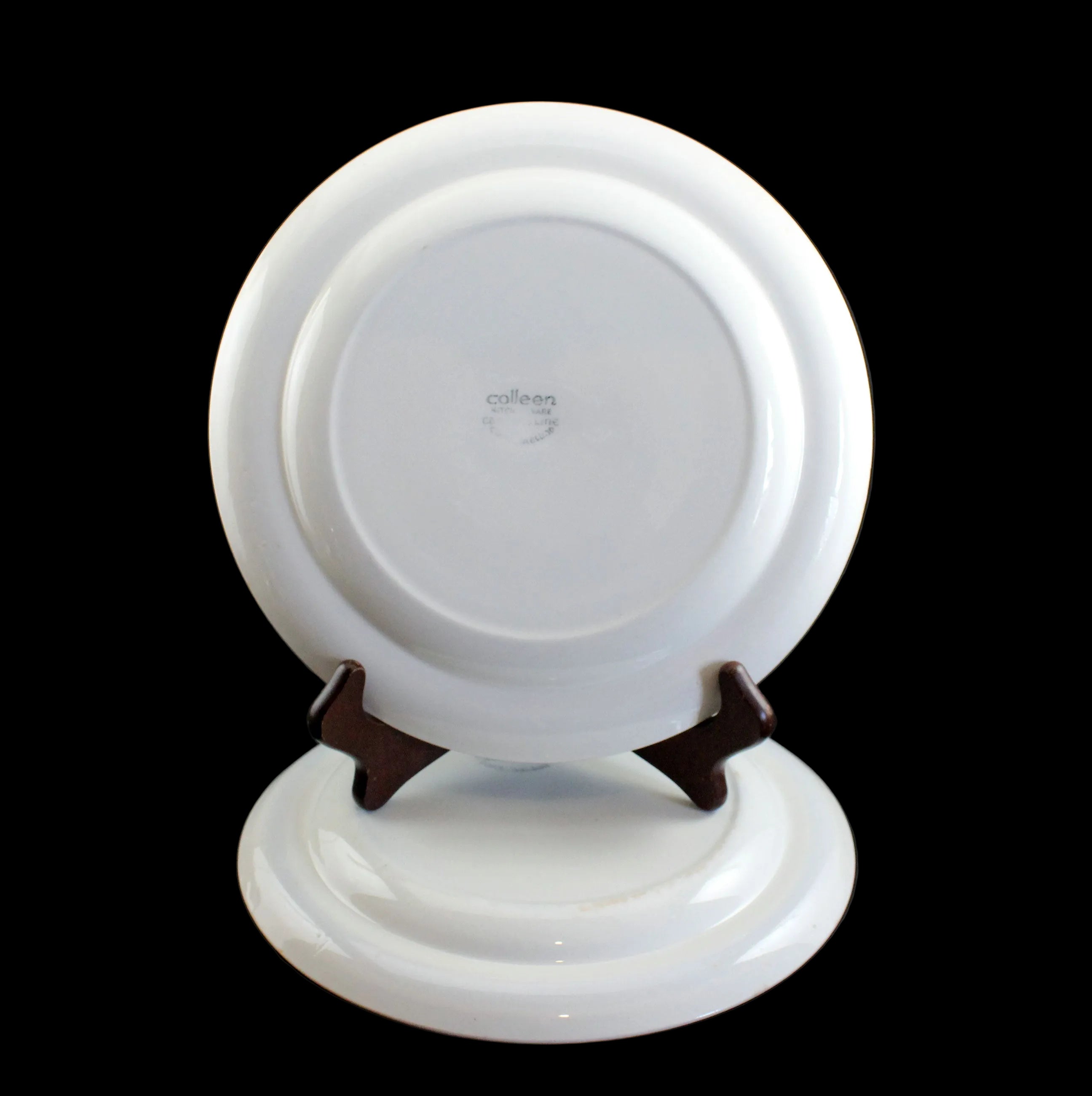 White ceramic plate on a stand with a black background