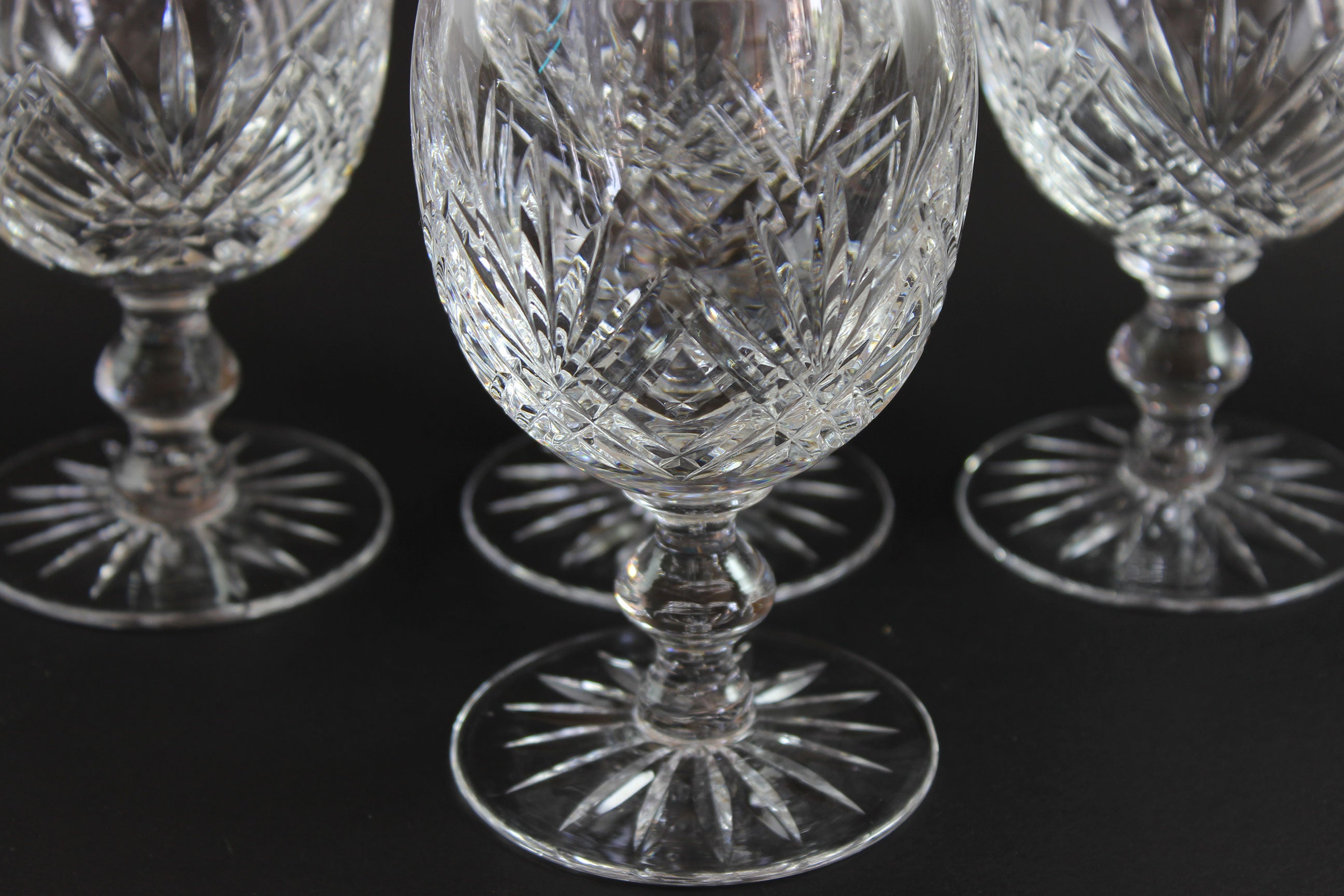 Set of crystal glasses with intricate designs on a black background