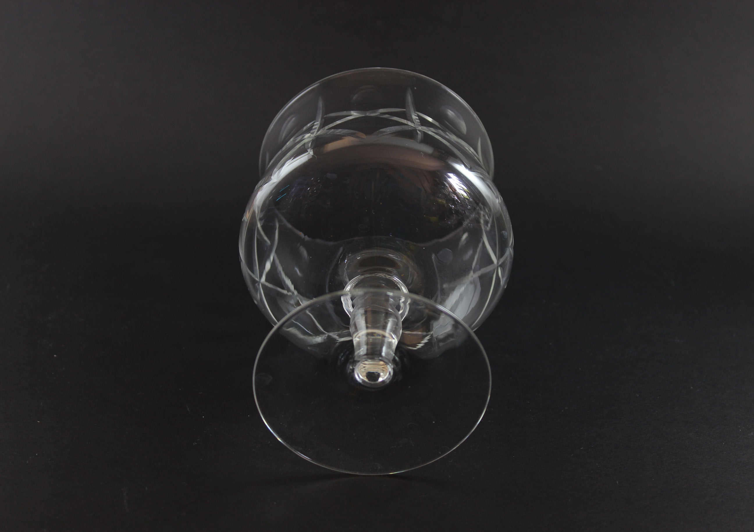 Clear crystal goblet with cross and olive cut pattern on a dark background