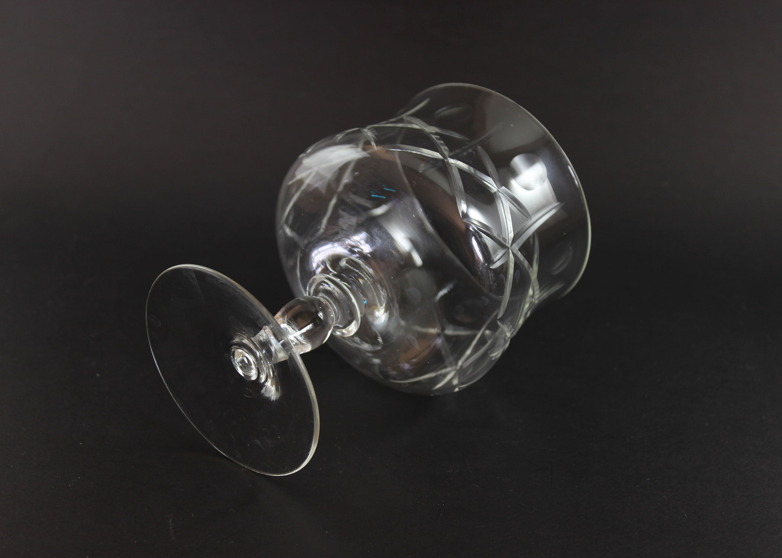 Clear crystal goblet with cross and olive cut pattern on a dark background