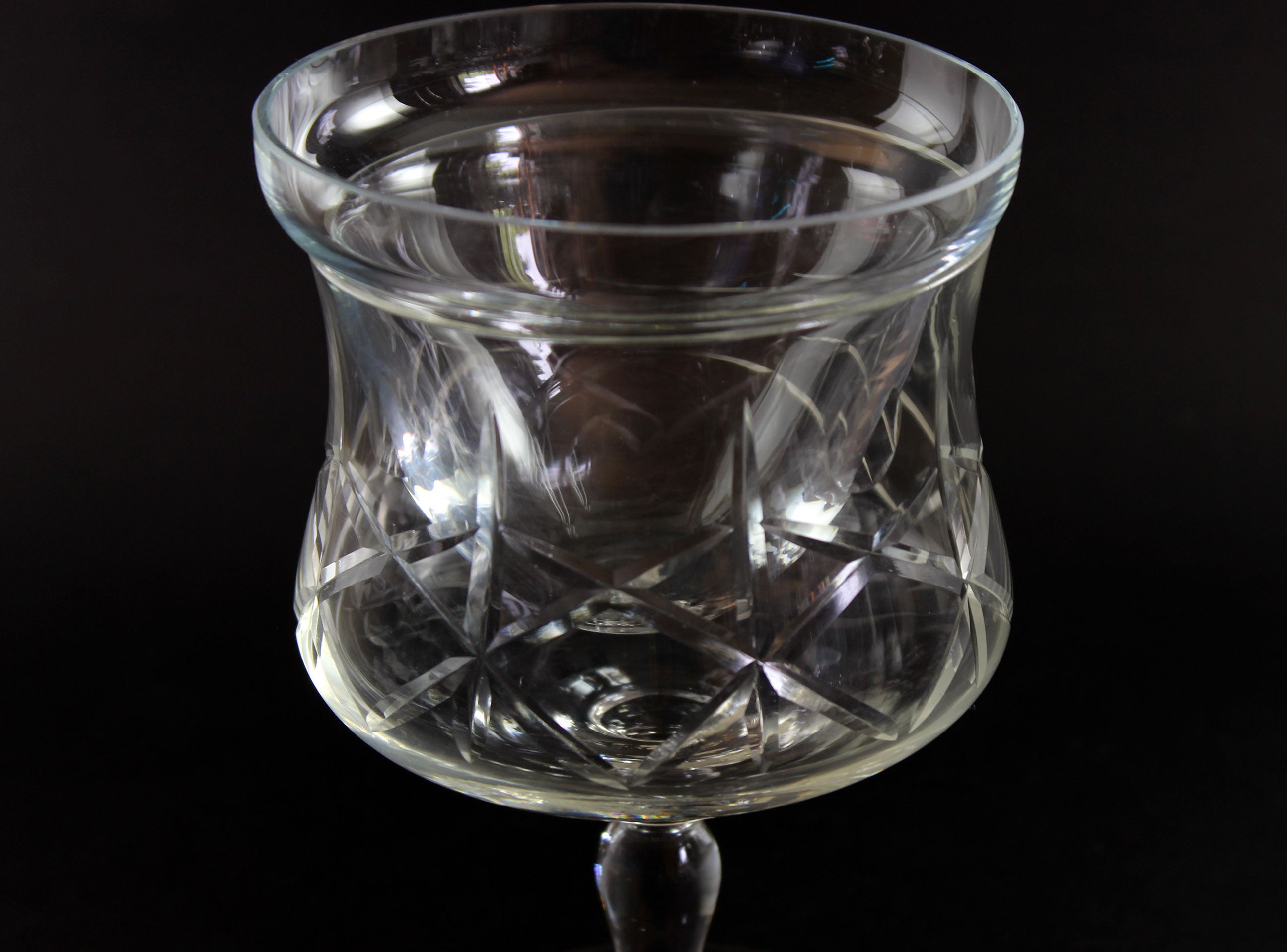 Set of clear glass tumblers with cross and olive cut pattern on a dark background