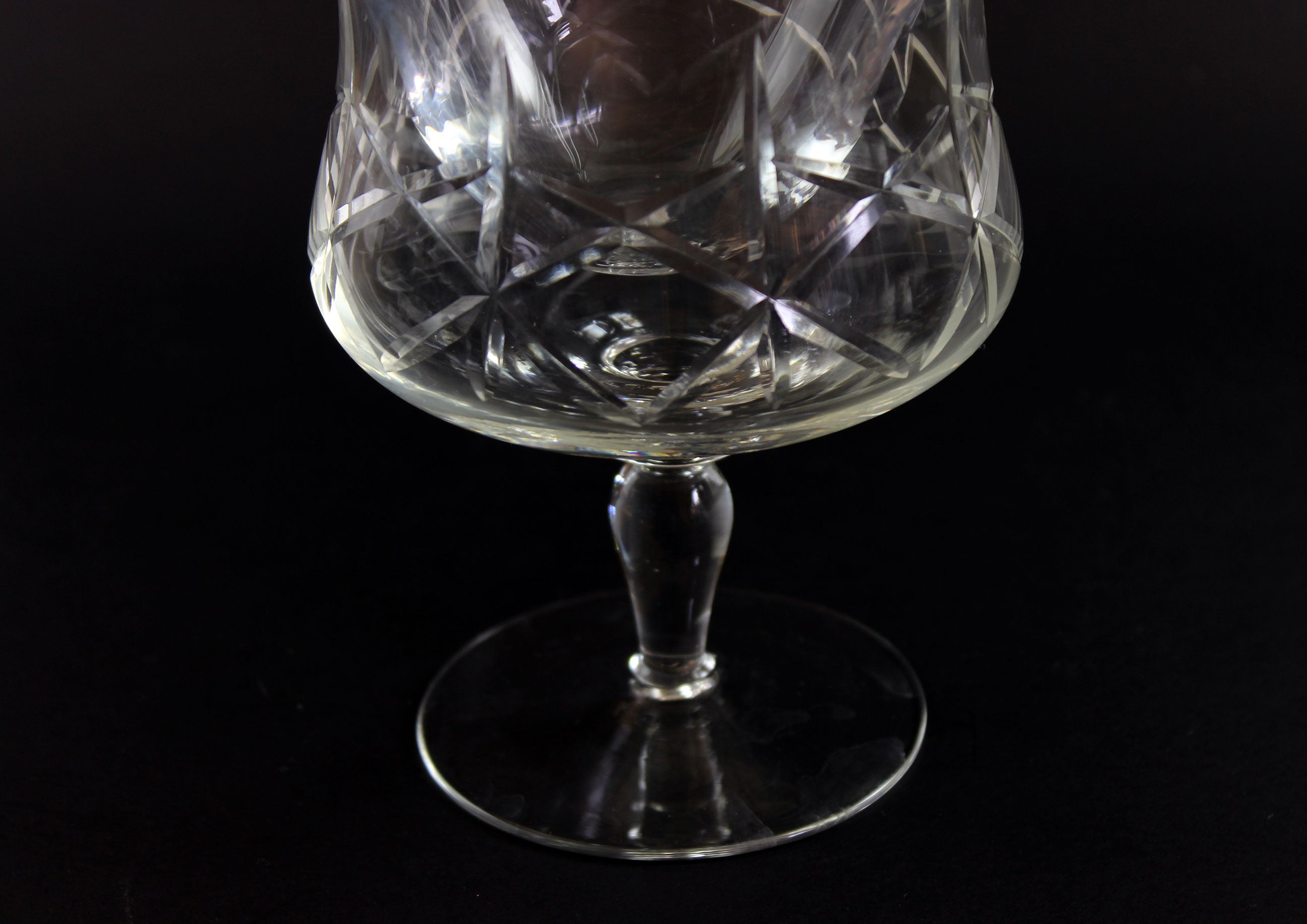 Crystal glass with cut patterns on a black background