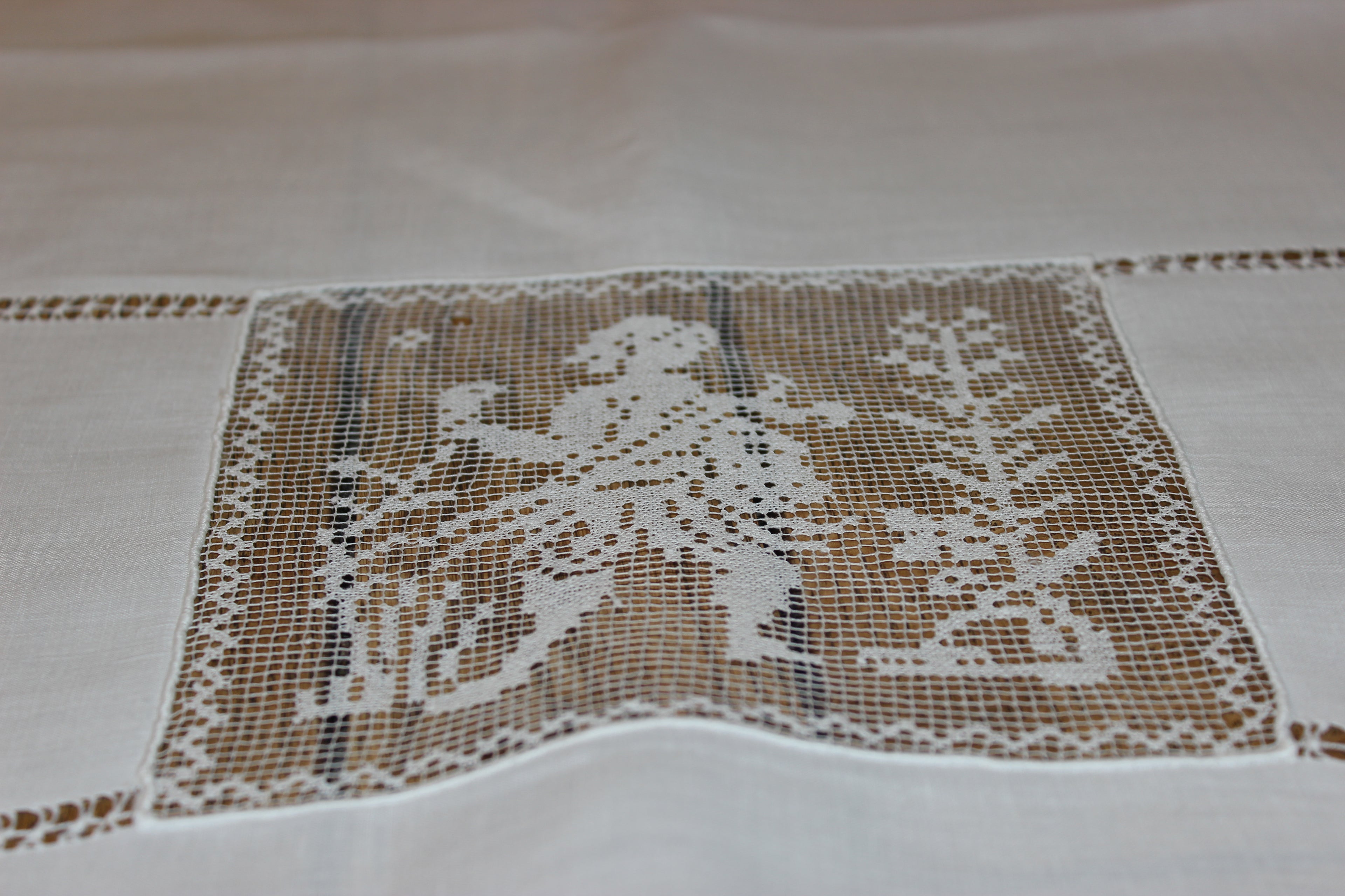 Decorative lace tablecloth with intricate patterns on a plain background