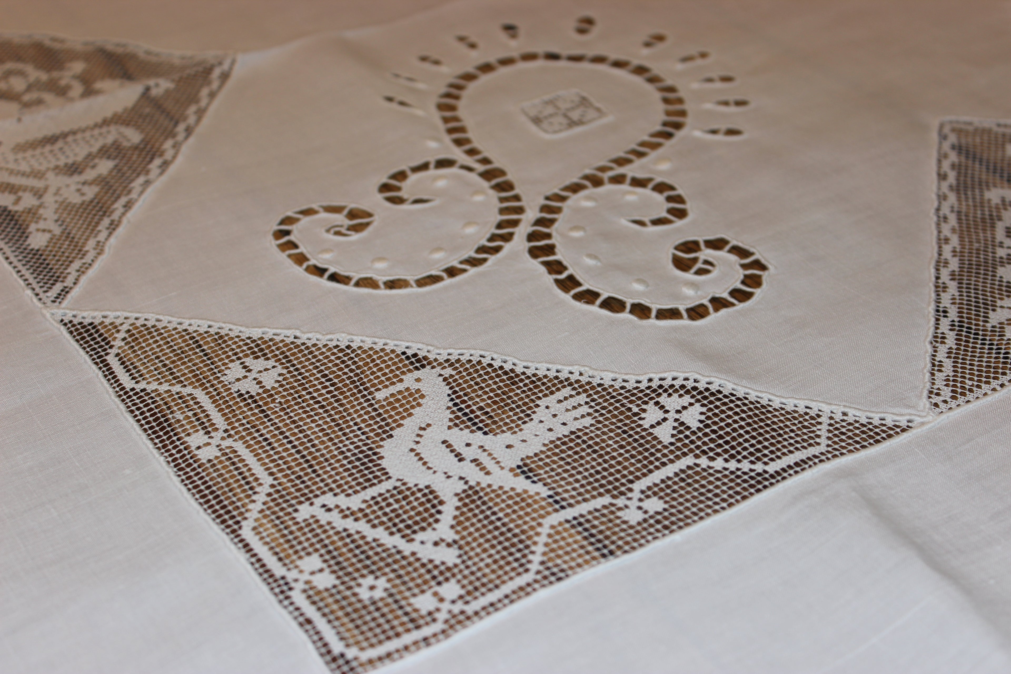 Close-up of a lace tablecloth with intricate patterns on a white background