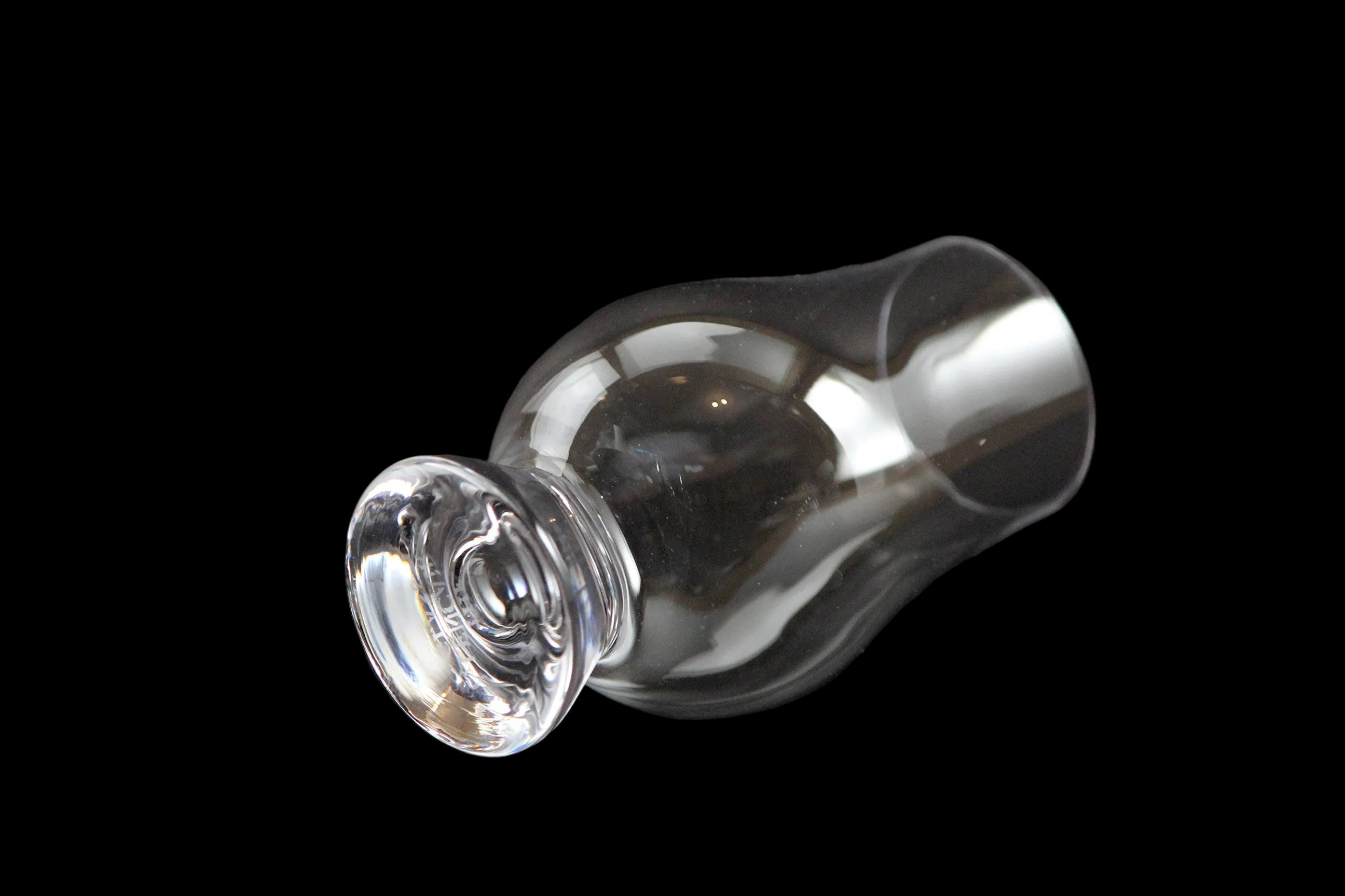 Four clear glass whisky glasses on a black background