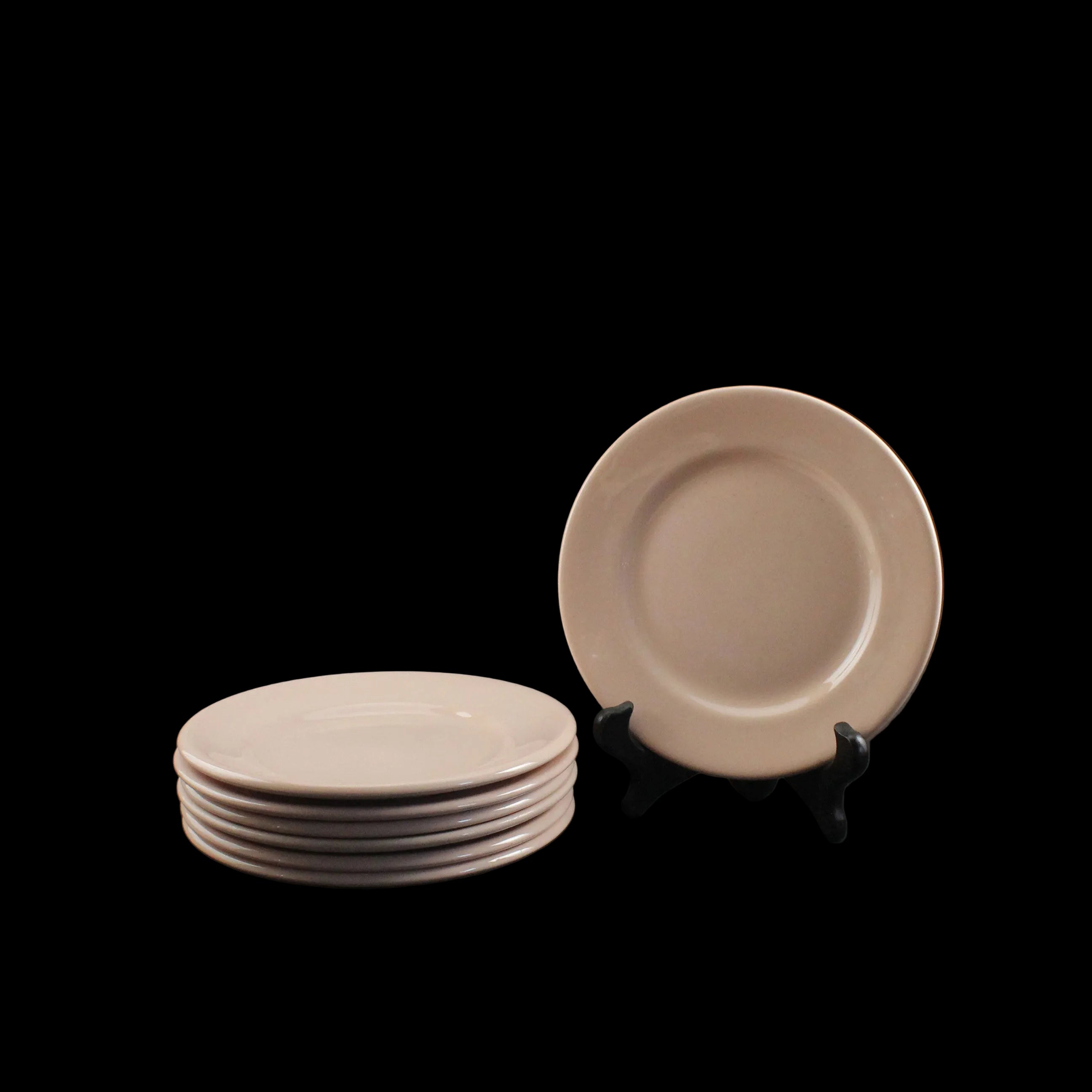 Set of pink ceramic plates on a dark background