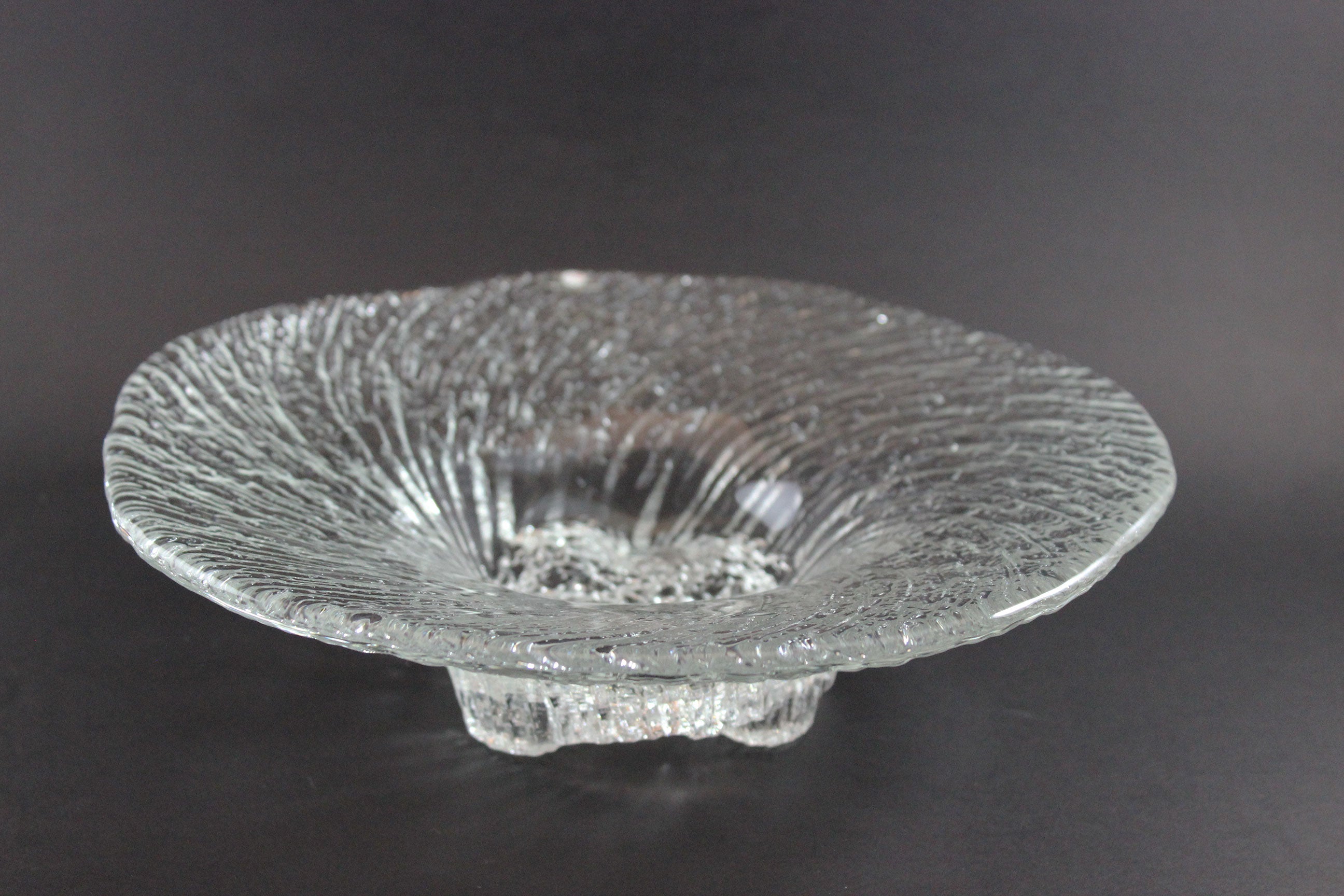 Clear glass bowl with textured design on a dark background