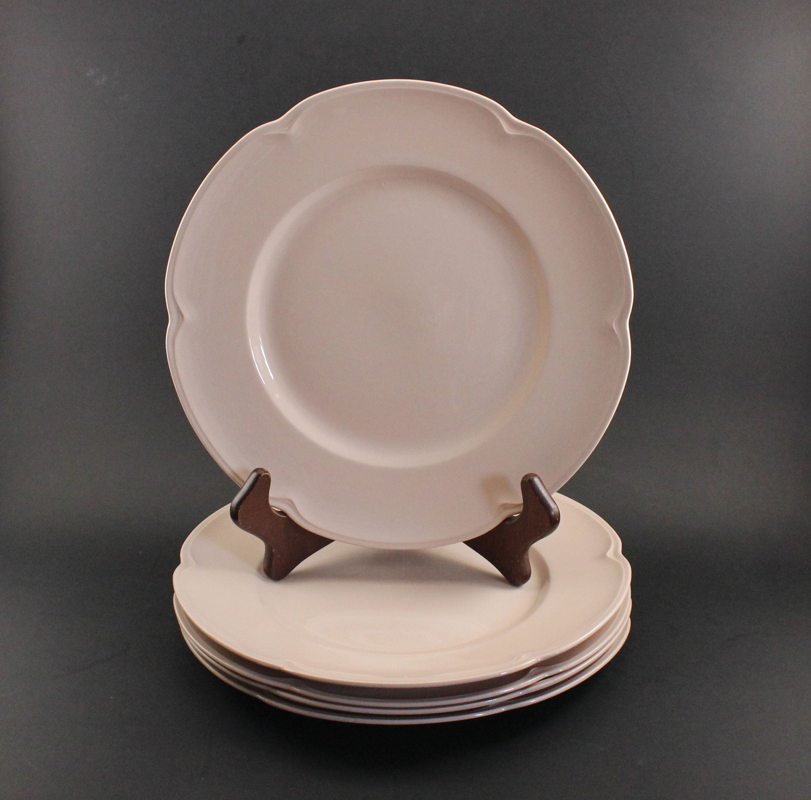 Set of pink ceramic petalware plates on a dark gray background