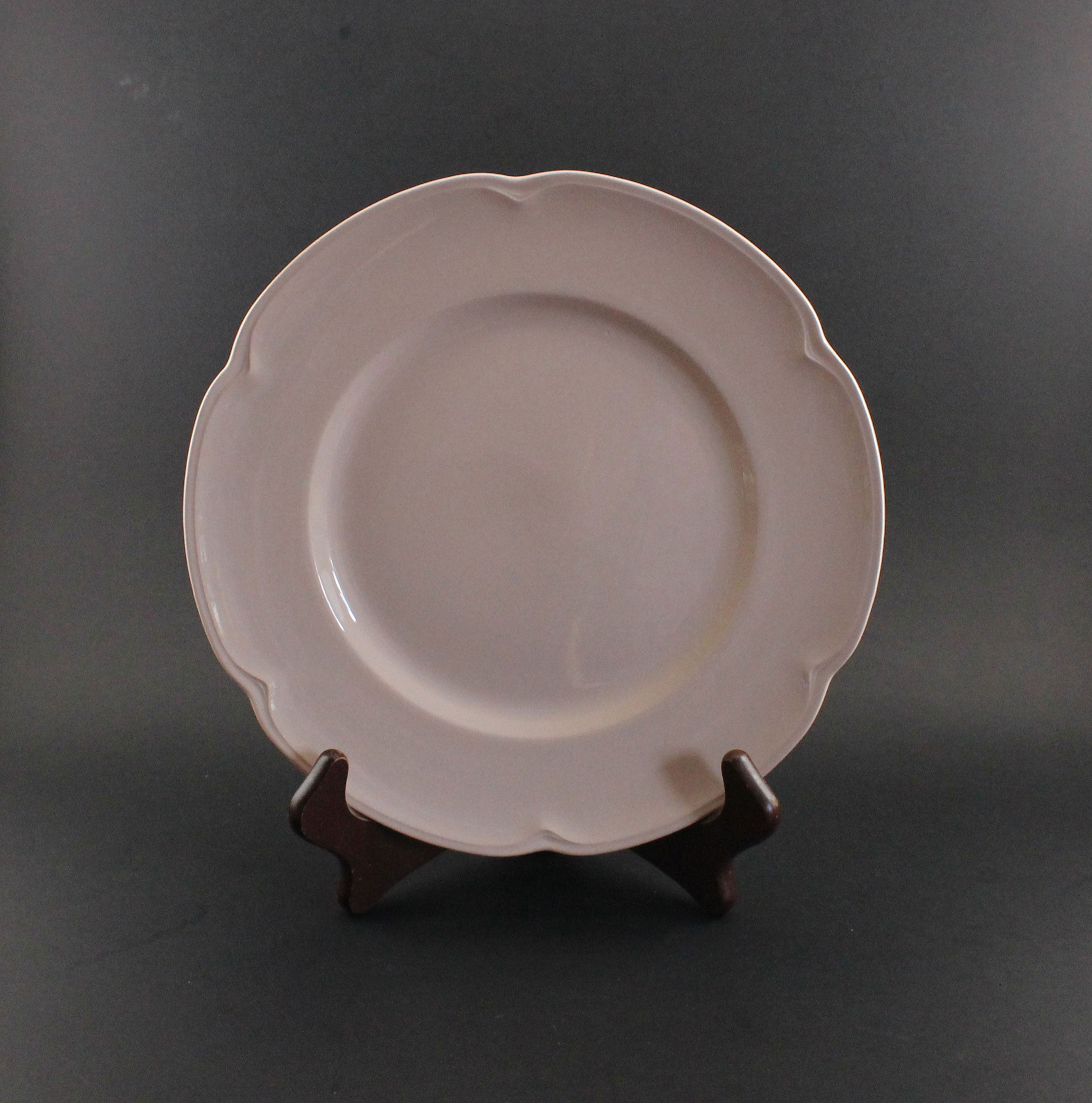 Pink ceramic petalware plate on a dark gray background