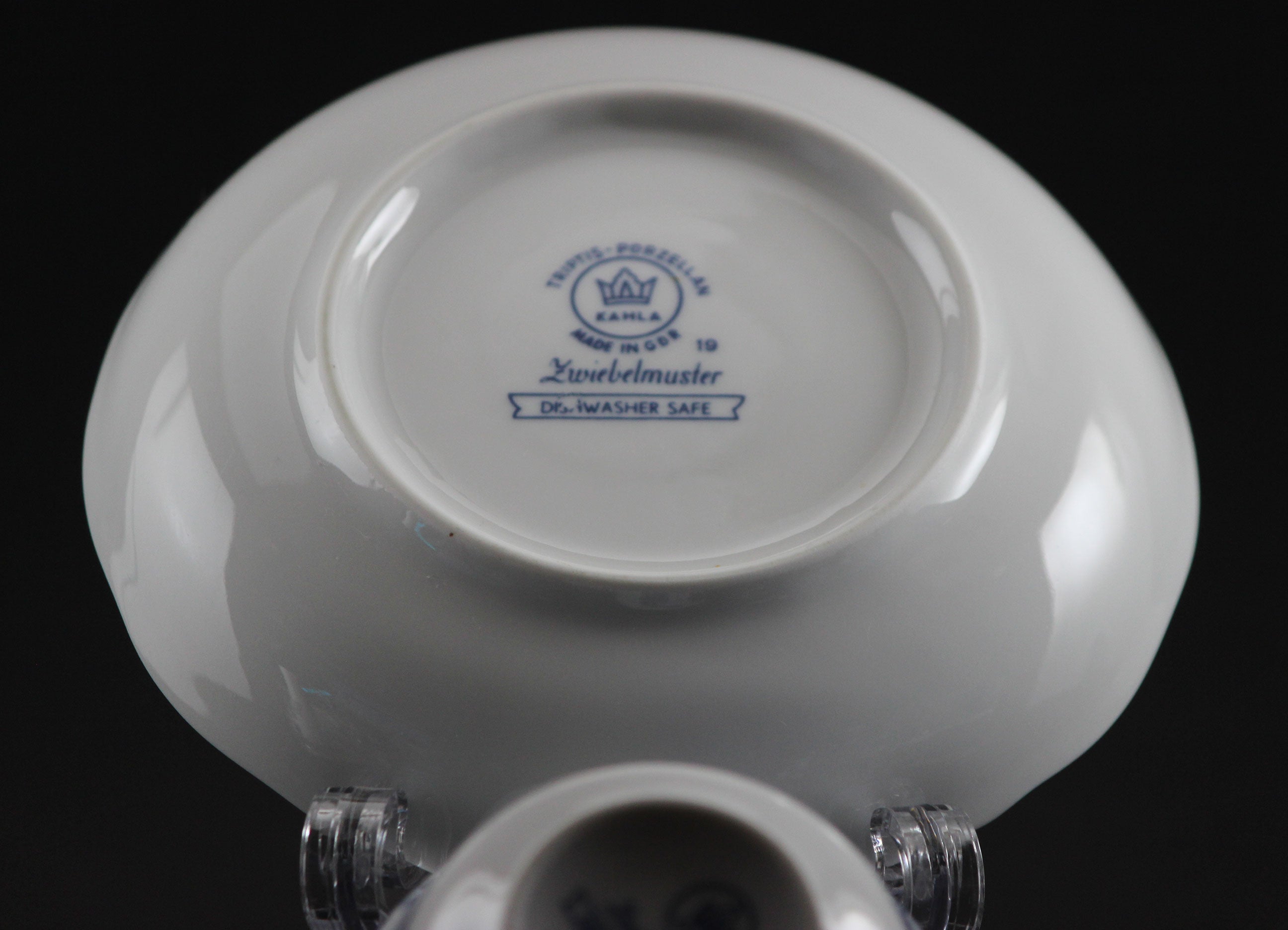 Porcelain teacup and saucer with blue floral patterns on a dark background