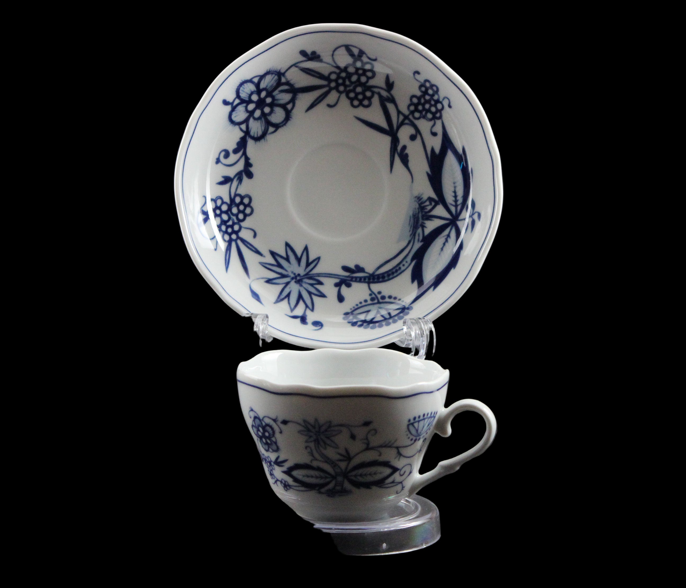 Ceramic teacup and saucer with blue floral patterns on a gray background