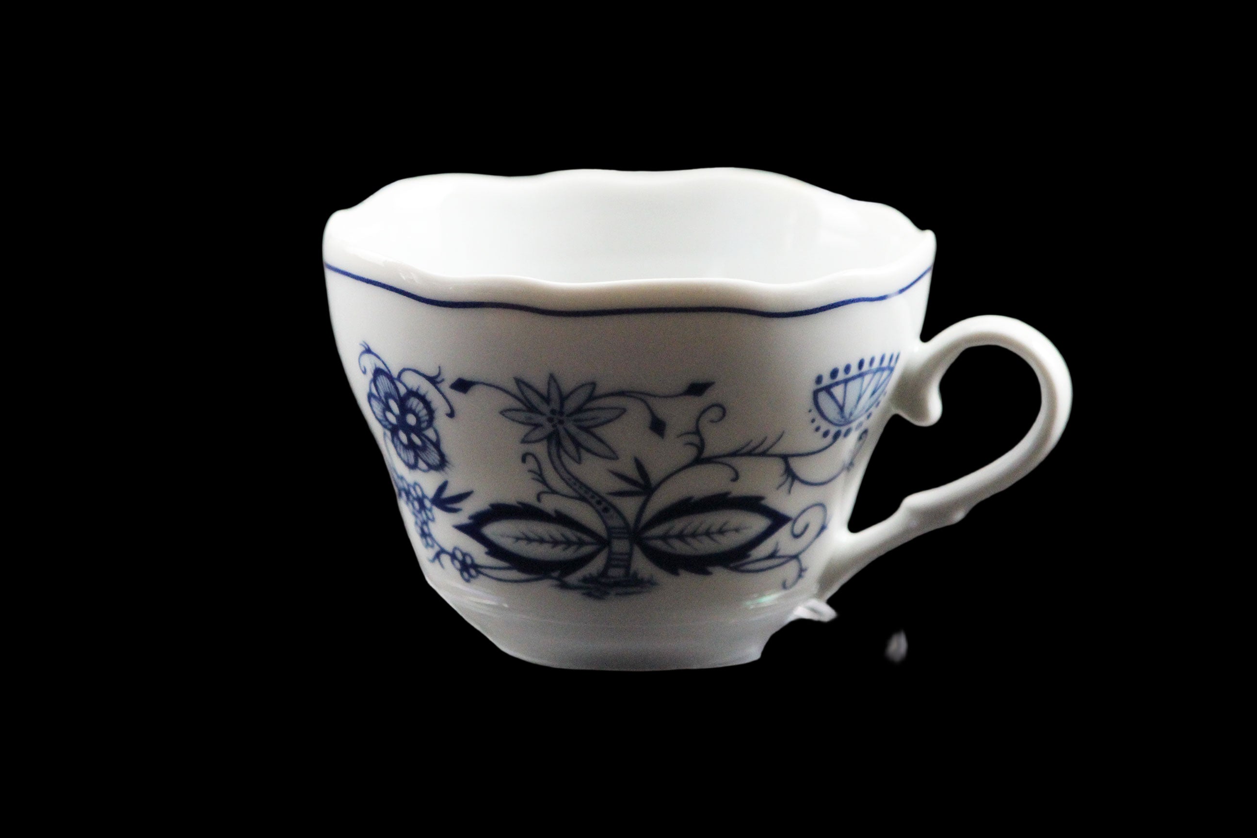 White ceramic cup with blue floral patterns on a clear stand against a dark background