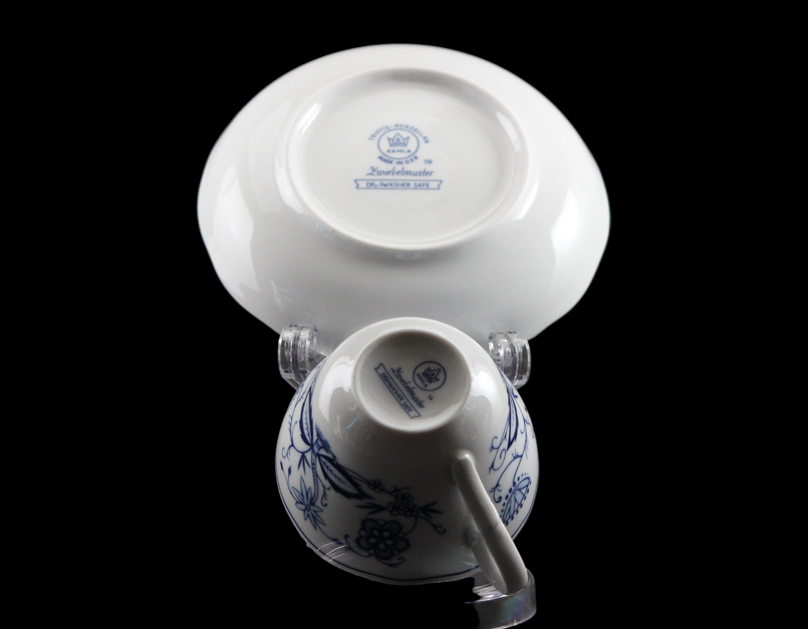 Porcelain teacup and saucer with blue floral patterns on a black background