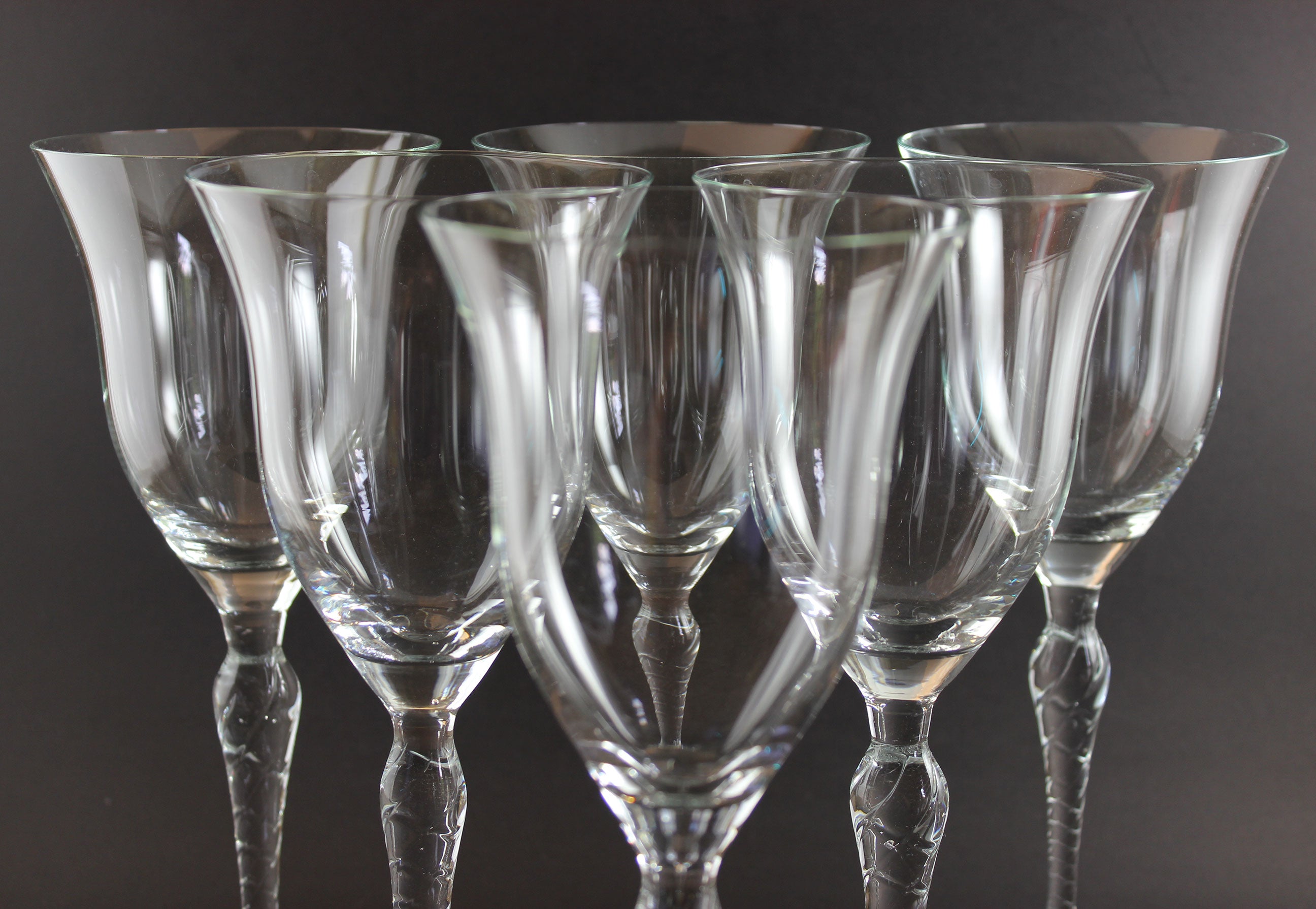 Set of clear glass wine glasses on a dark background