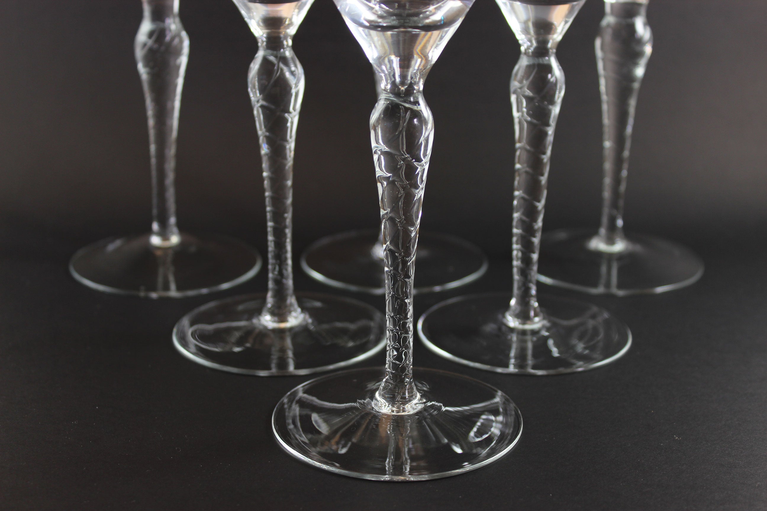 Set of clear glass goblets on a dark background
