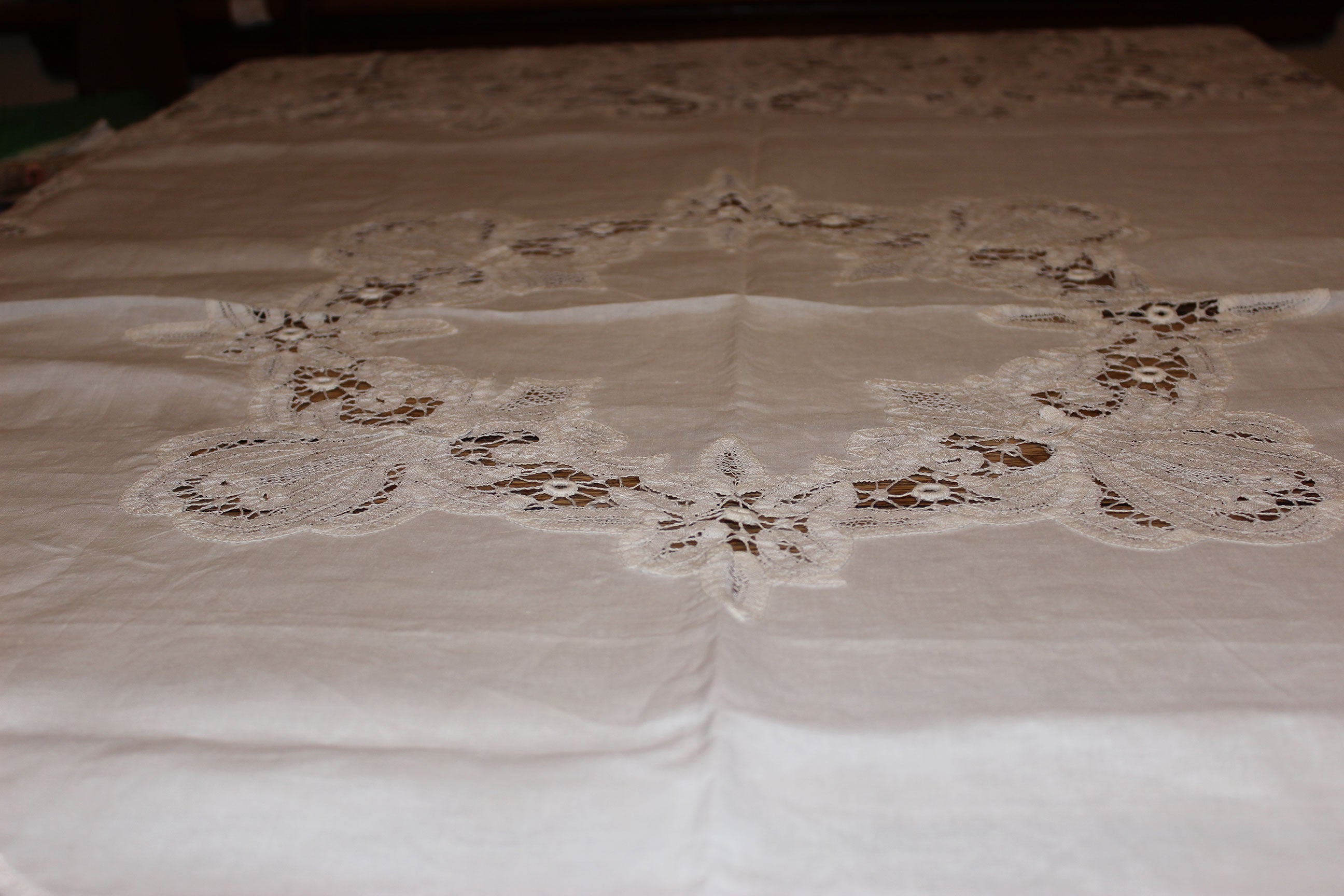 Lace tablecloth on a table with a floral pattern
