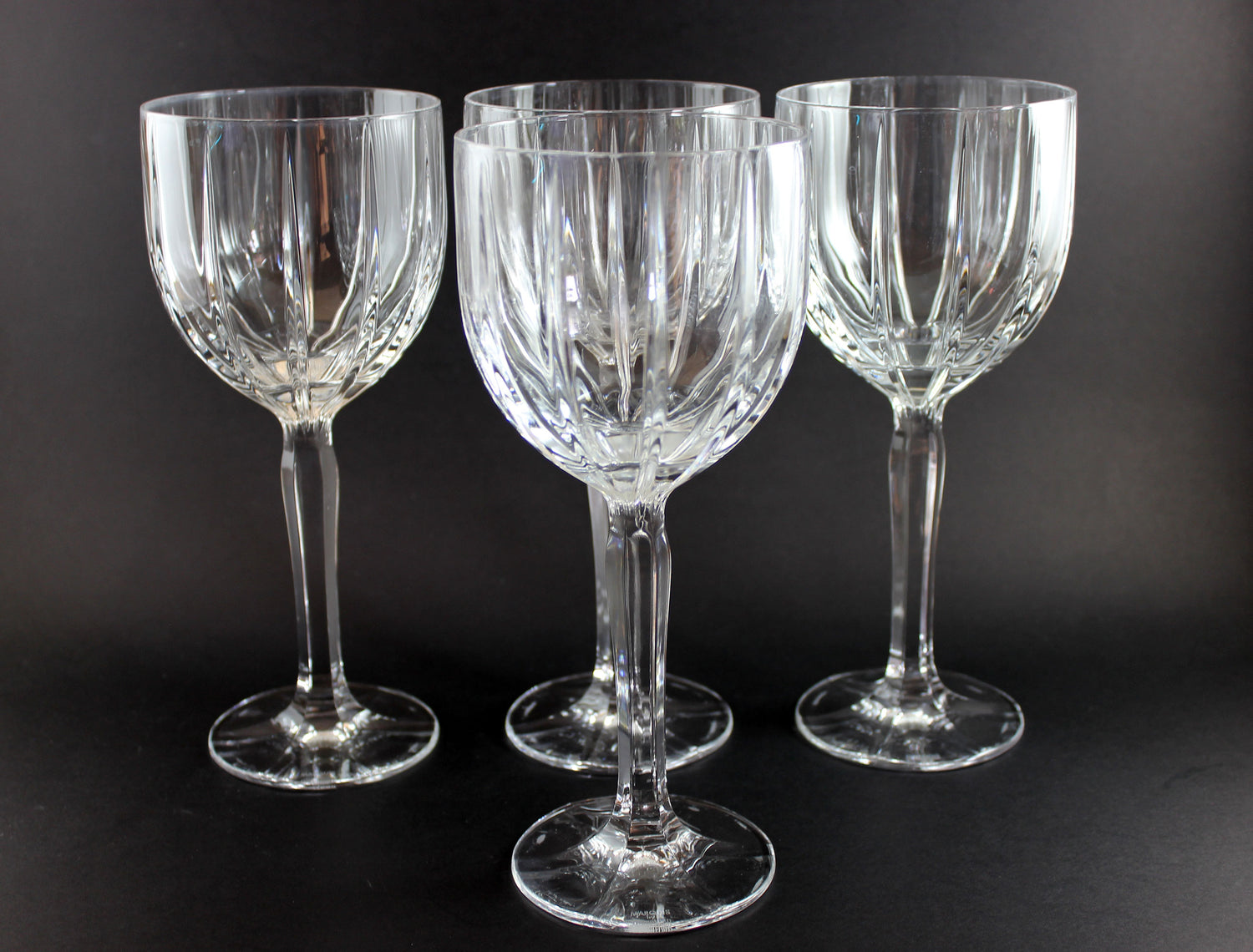 Four crystal wine glasses on a black background