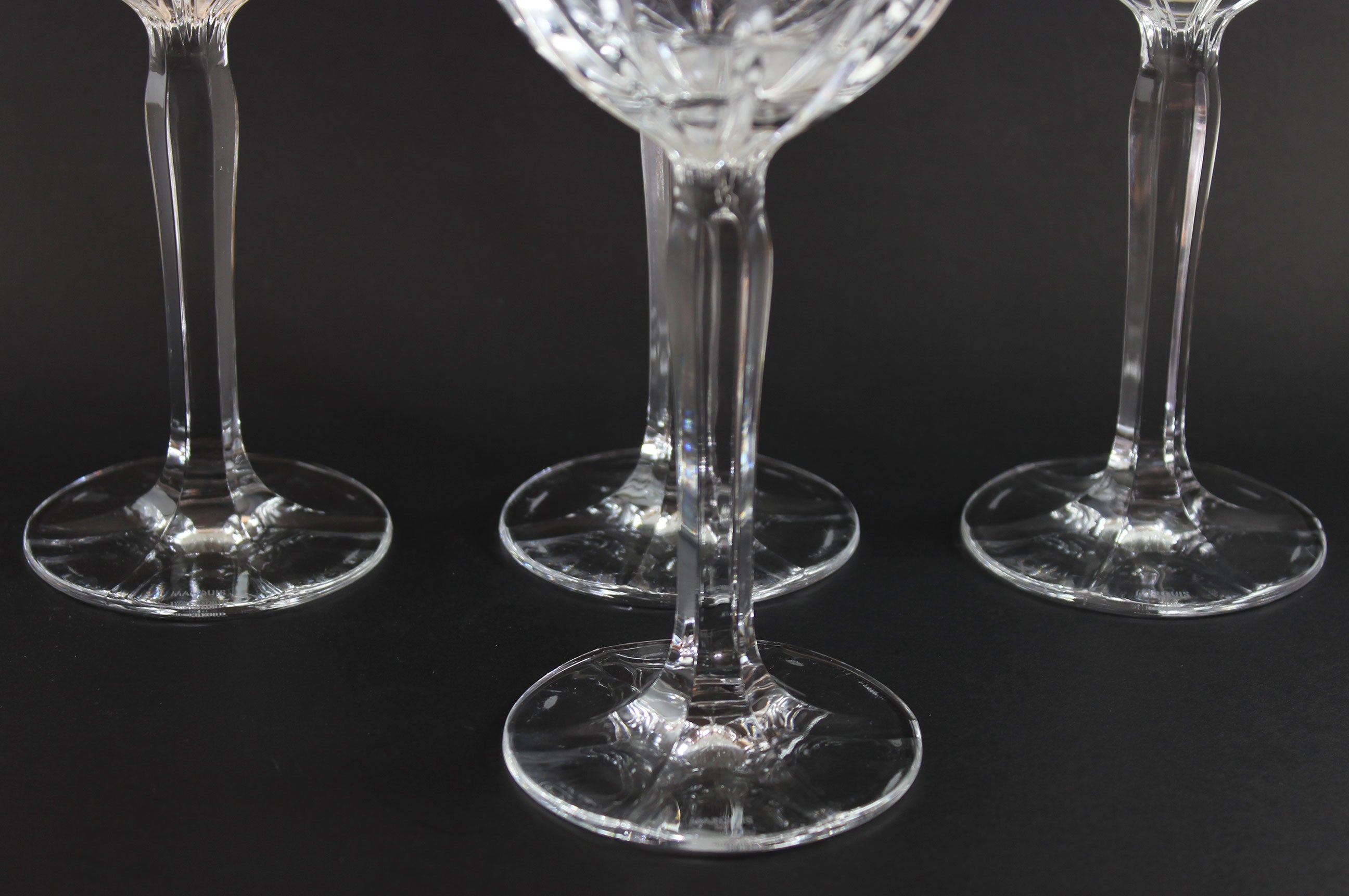 Three clear glass wine glasses on a black background