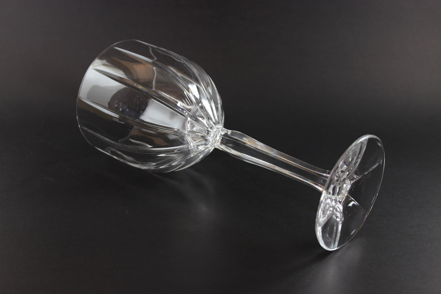 Clear glass wine goblet on a black background