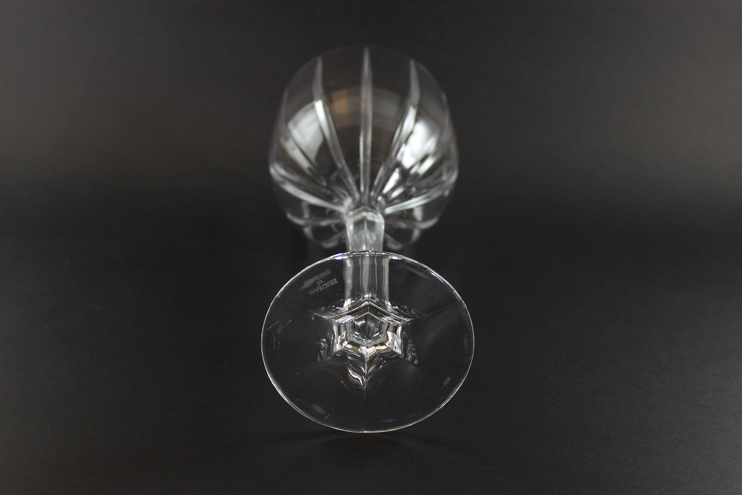 Clear glass wine goblet on a black background