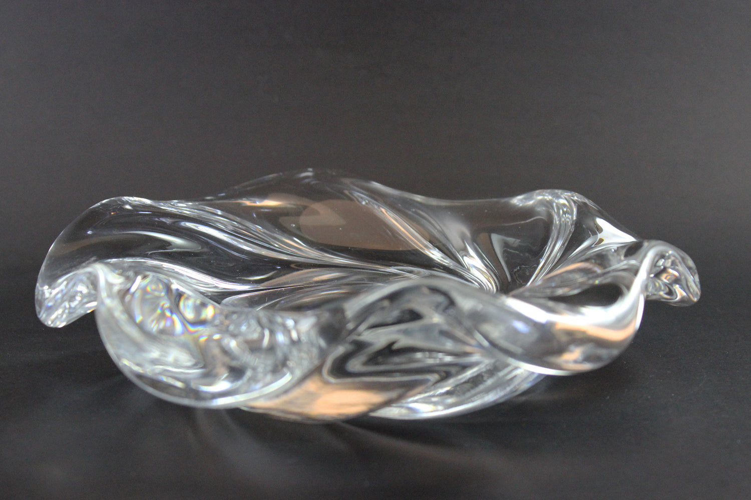 Clear crystal bowl with wavy design on a black background