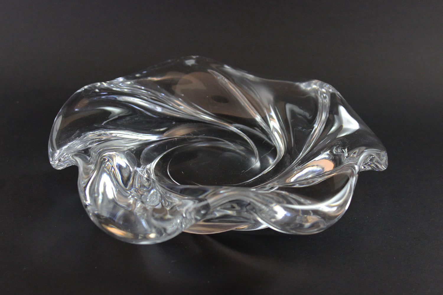 Clear crystal bowl with wavy design on a black background
