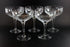 Set of six clear champagne coupe glasses on a black background