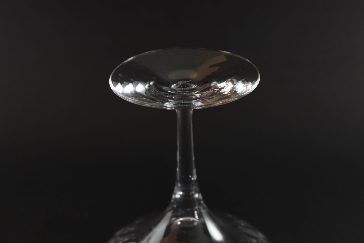 Set of six clear champagne coupe glasses on a black background