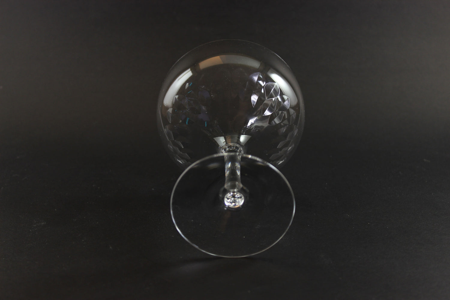Set of six clear champagne coupe glasses on a black background