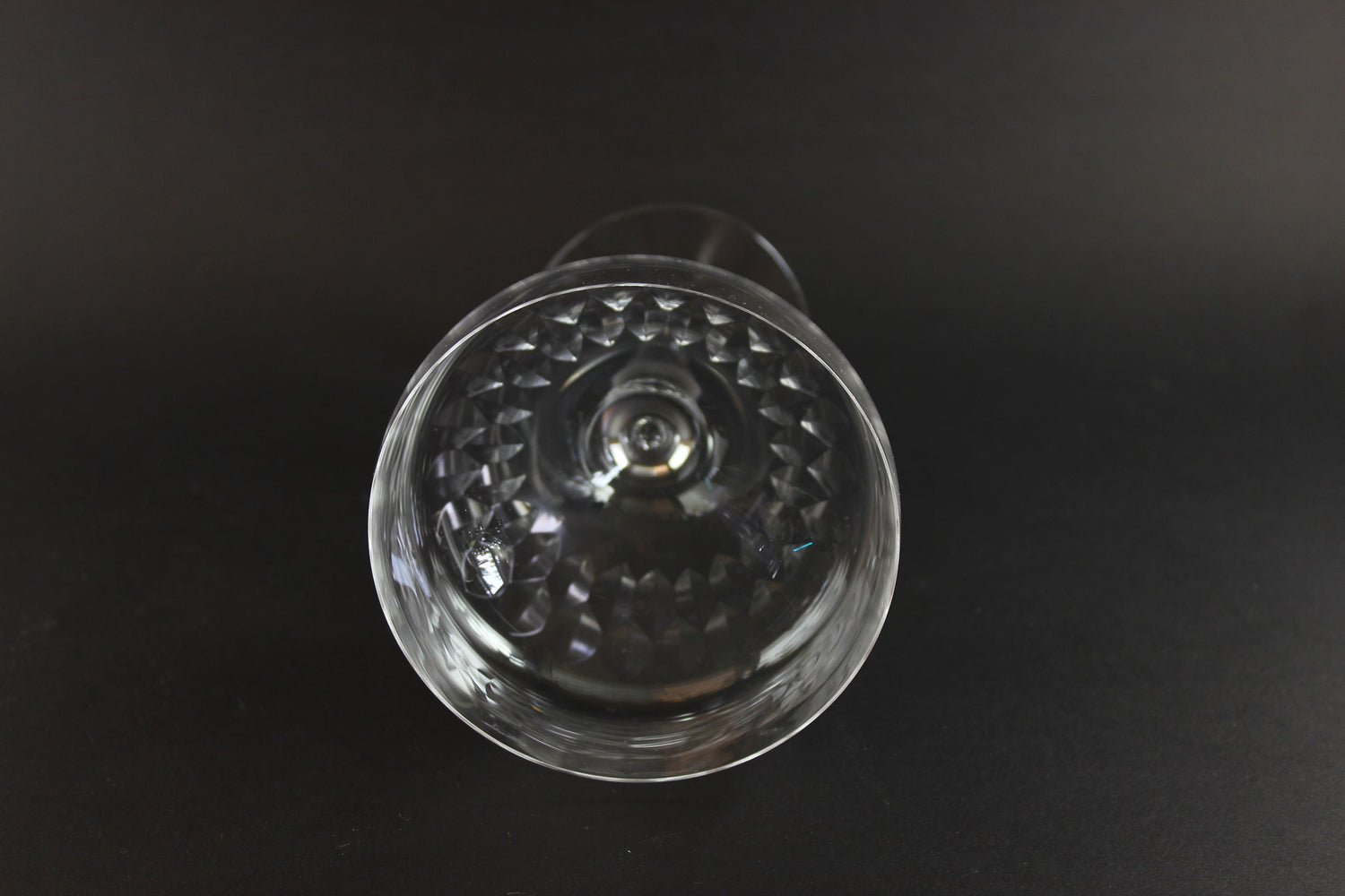 Set of six clear champagne coupe glasses on a black background